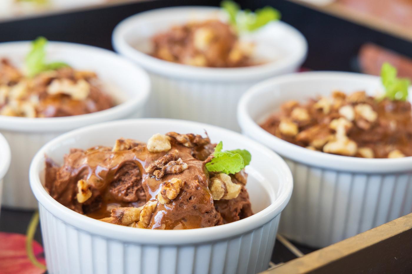 chocolate desserts with walnuts and mint garnish served in white ramekins
