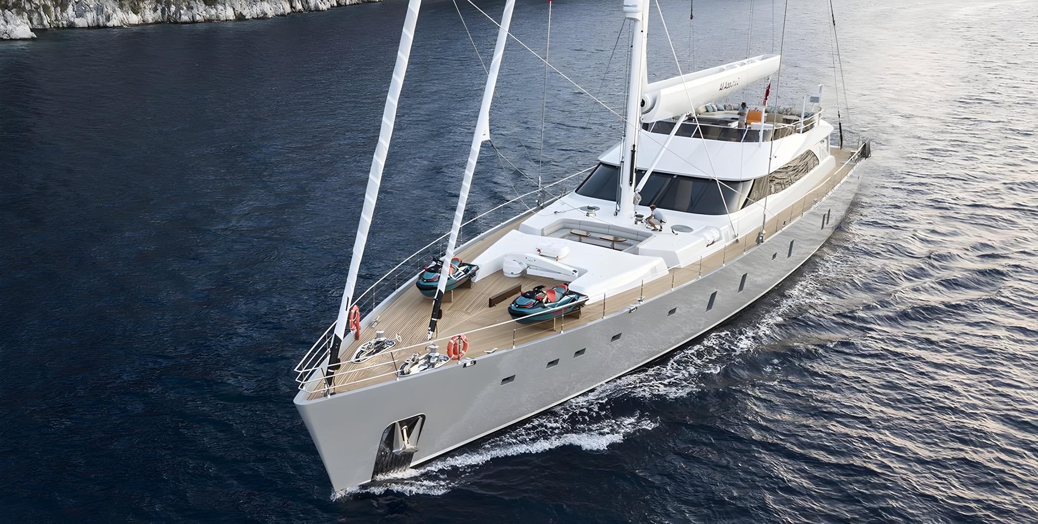 aerial view of white sailing yacht underway with two tenders on foredeck