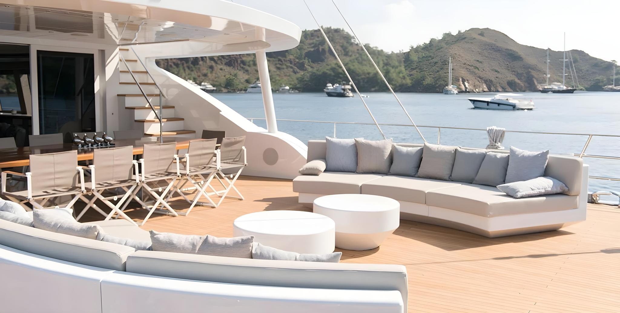 yacht main deck with curved sectional sofa, white coffee tables and teak flooring