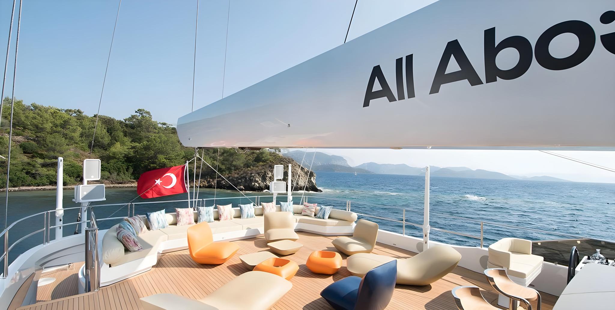 luxury yacht aft deck with curved white seating, colorful cushions and Turkish flag