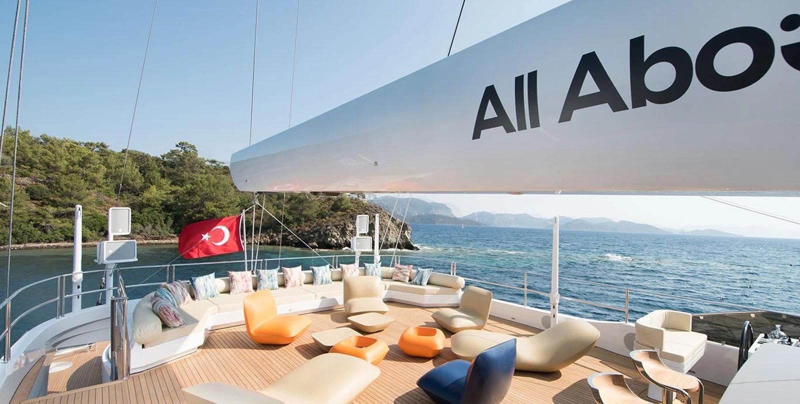 luxury yacht aft deck with curved white seating, colorful cushions and Turkish flag