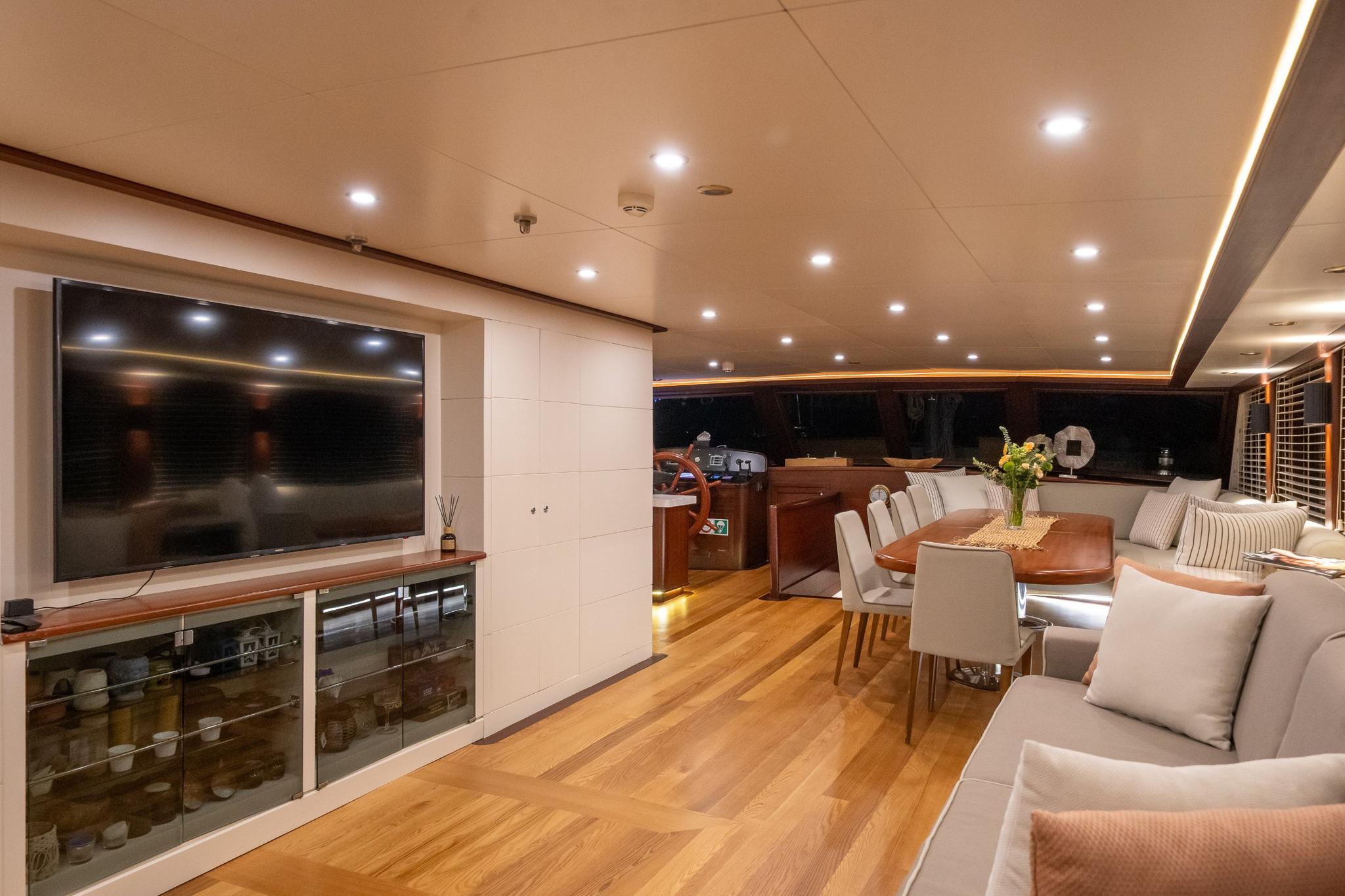 luxury yacht cinema room with large TV screen, white seating and entertainment setup
