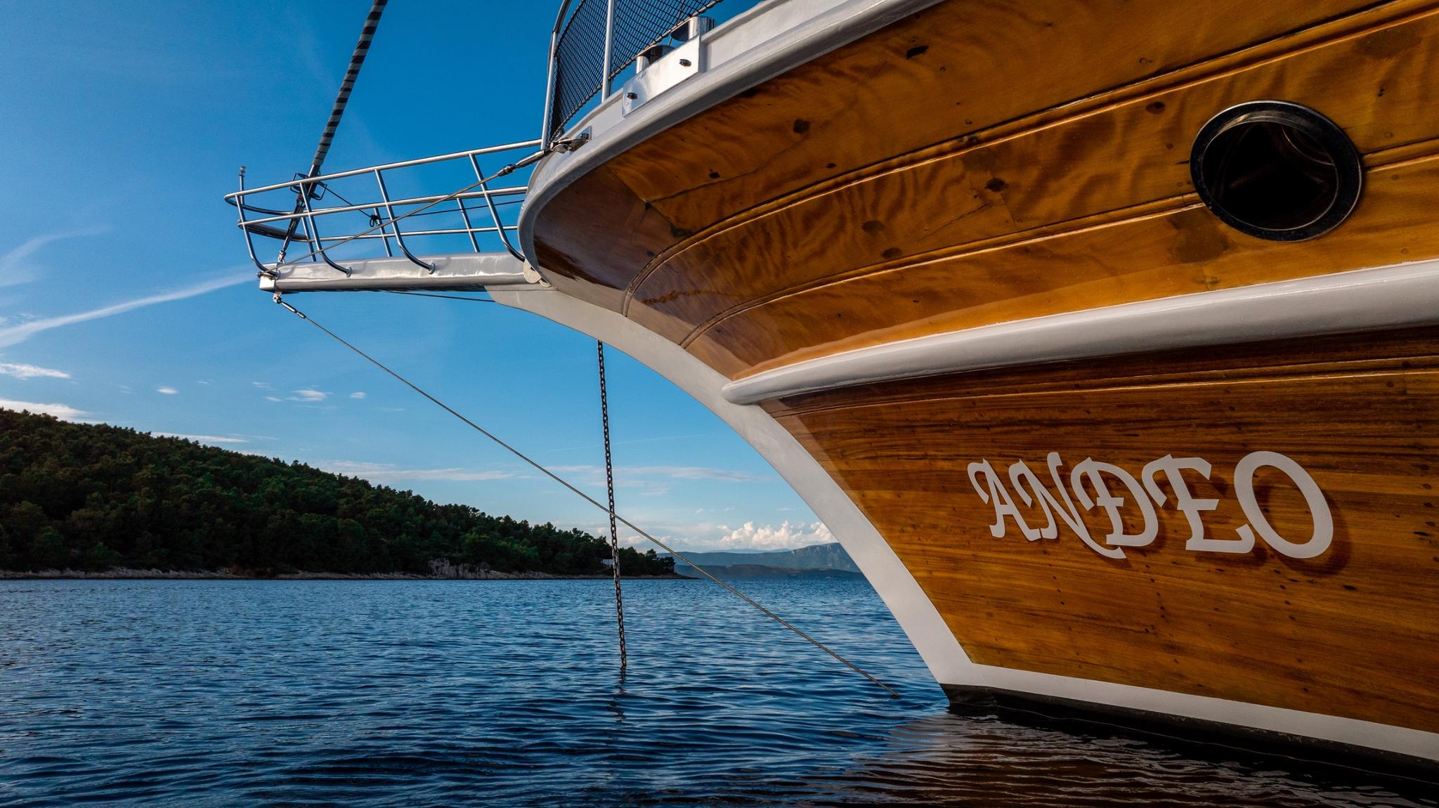 wooden gulet yacht bow showing hull construction and anchor chain in calm waters
