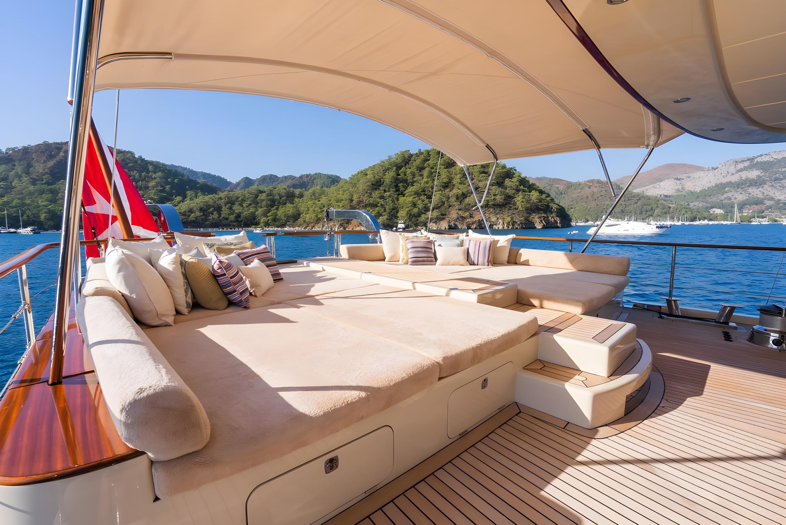 luxury yacht aft deck with curved cream seating, cushions and canopy overhead