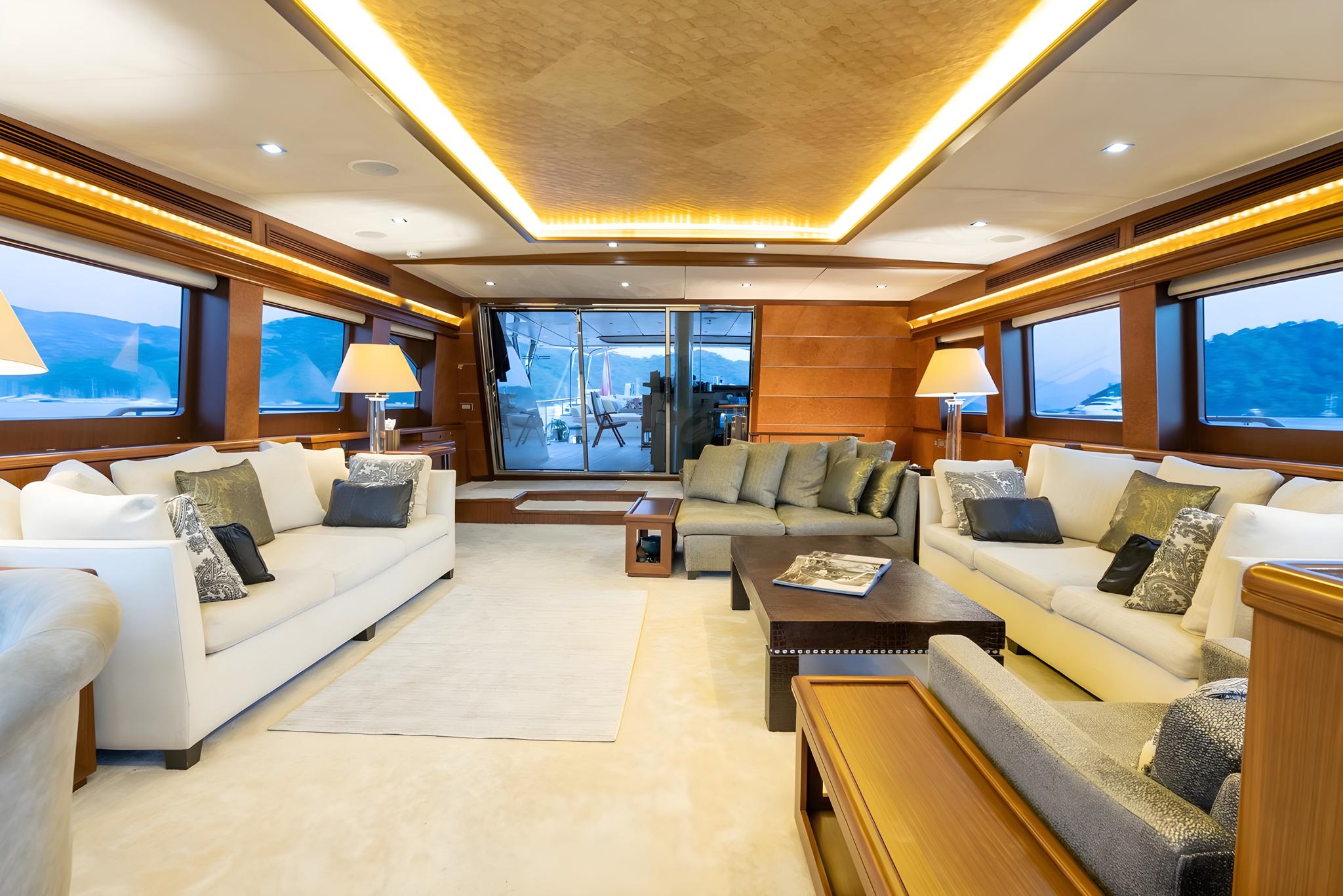 luxury yacht main salon with cream sofas, coffee table, and panoramic marina views