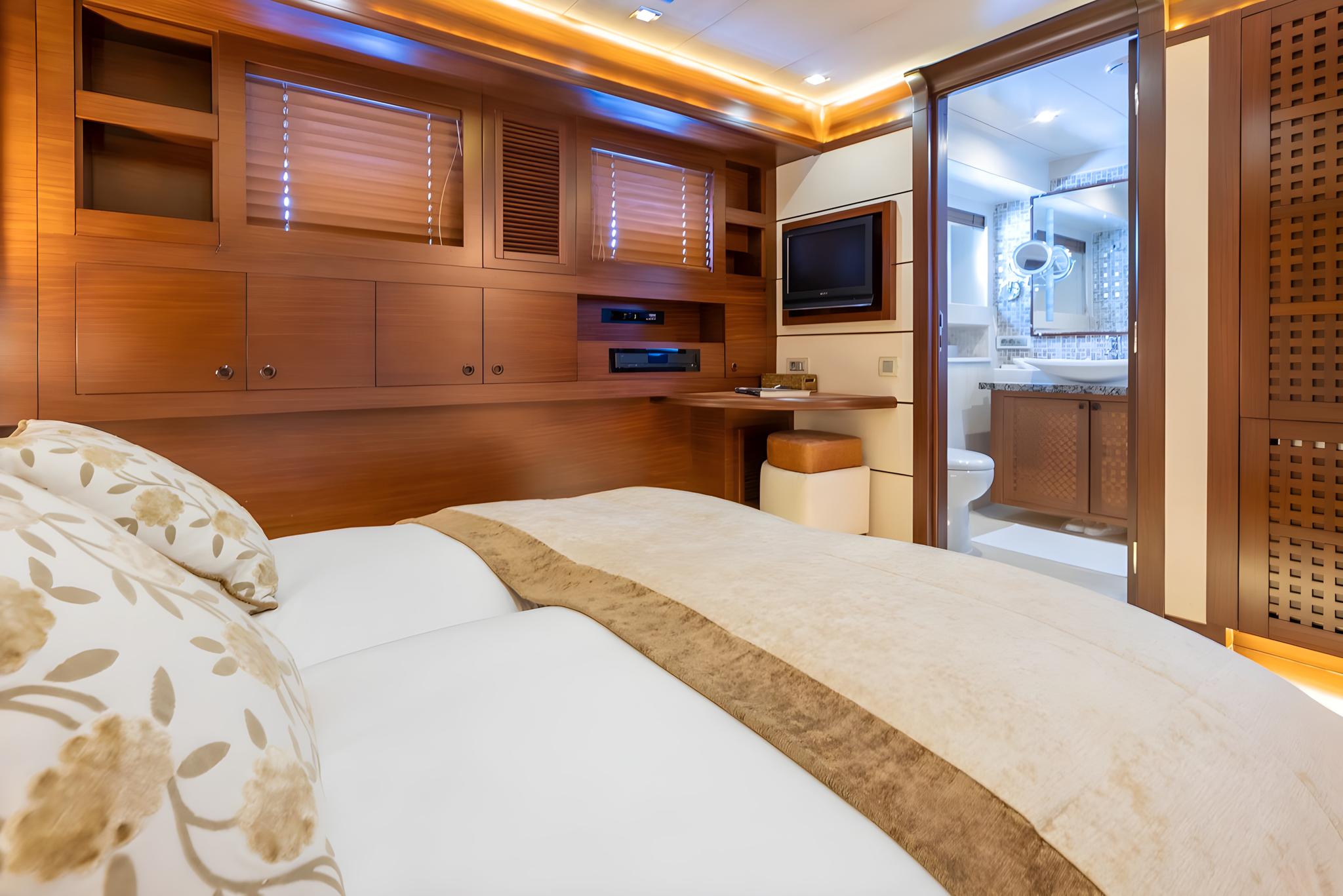 yacht cabin with double bed, wooden cabinetry, flat-screen TV, and ensuite bathroom visible