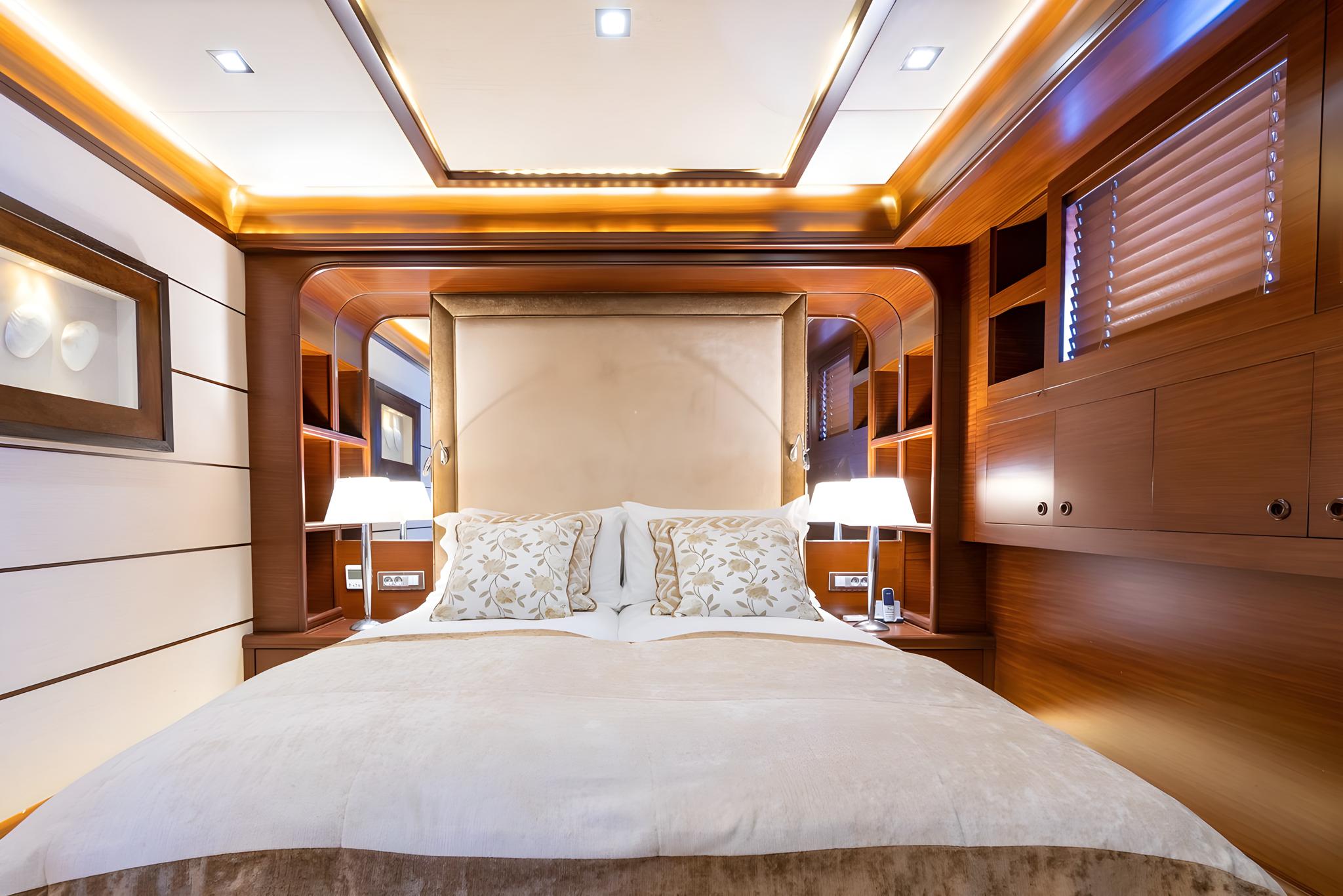 yacht master cabin with king bed, cream headboard, built-in wardrobes and ambient lighting