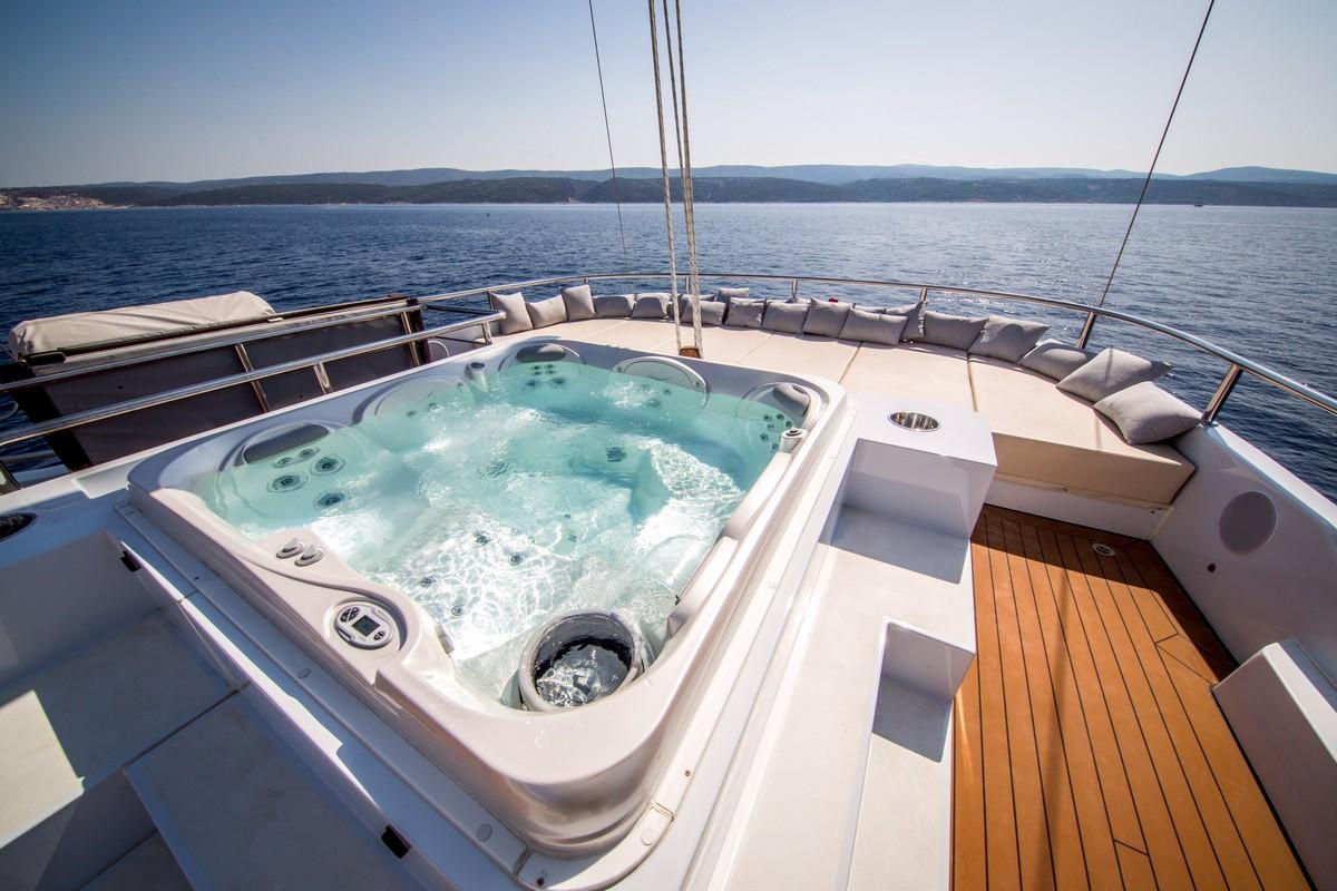 luxury yacht deck jacuzzi with curved seating and teak flooring
