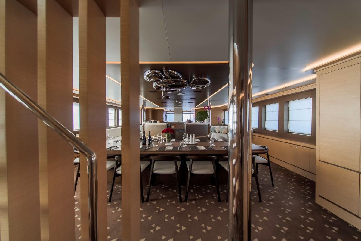 Luxury yacht formal dining room with wooden table wine glasses modern chandelier