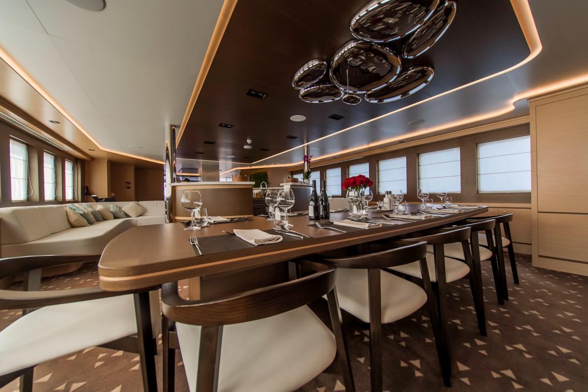 elegant yacht dining salon with oval table and modern lighting