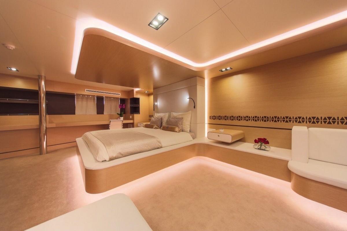 Luxury yacht master cabin featuring bed with warm LED ambient lighting