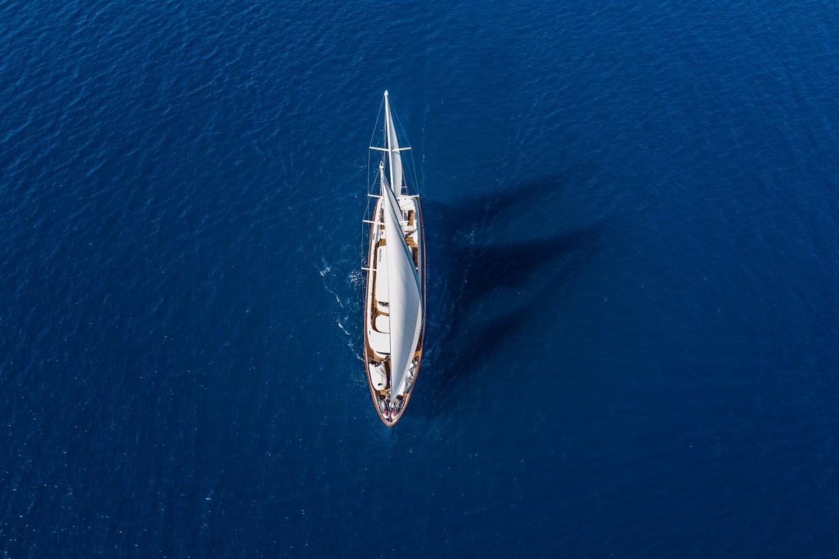 Aerial view of white sailing yacht anchored in deep blue Mediterranean waters