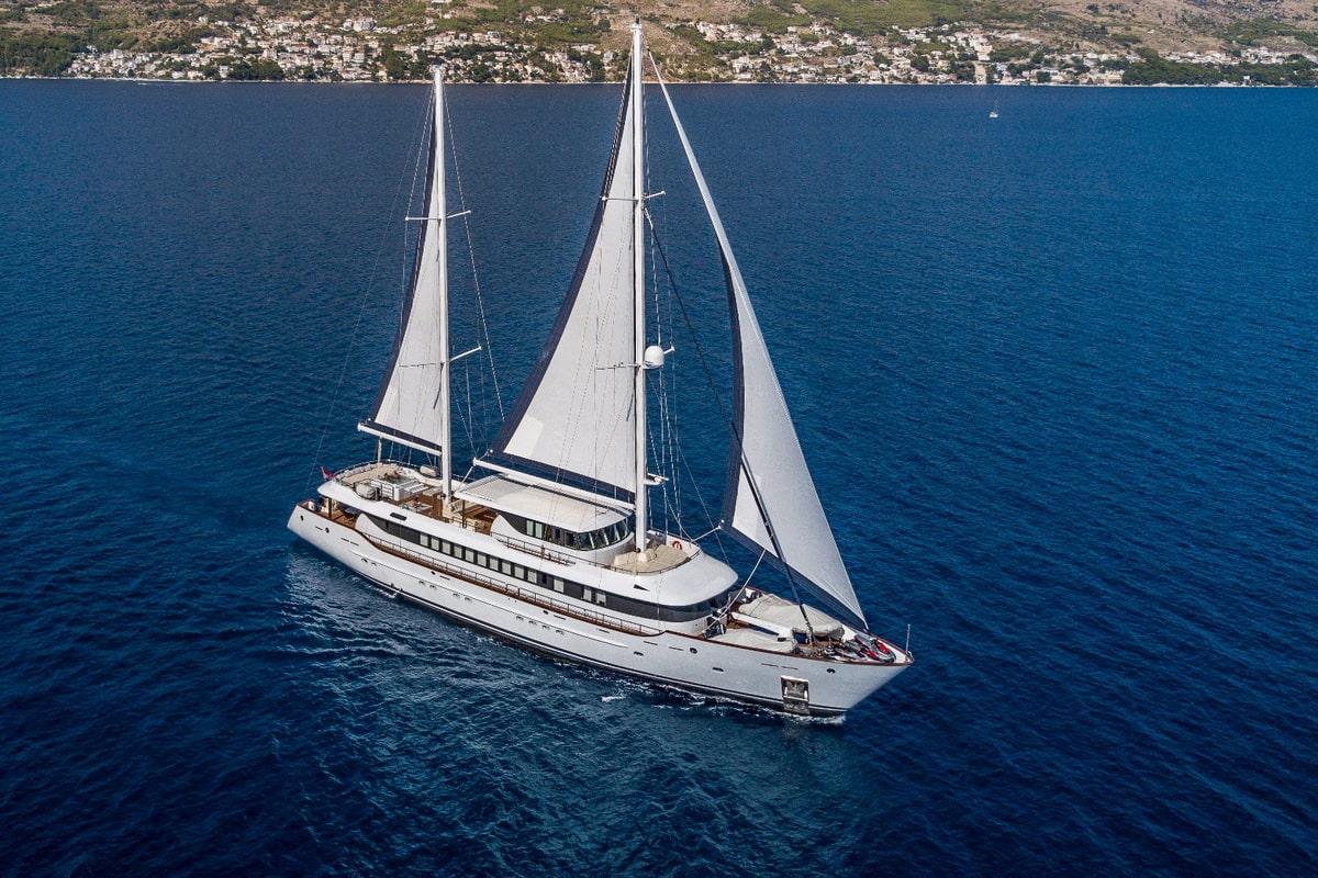 aerial view white luxury gulet sailing with full sails Mediterranean coastline