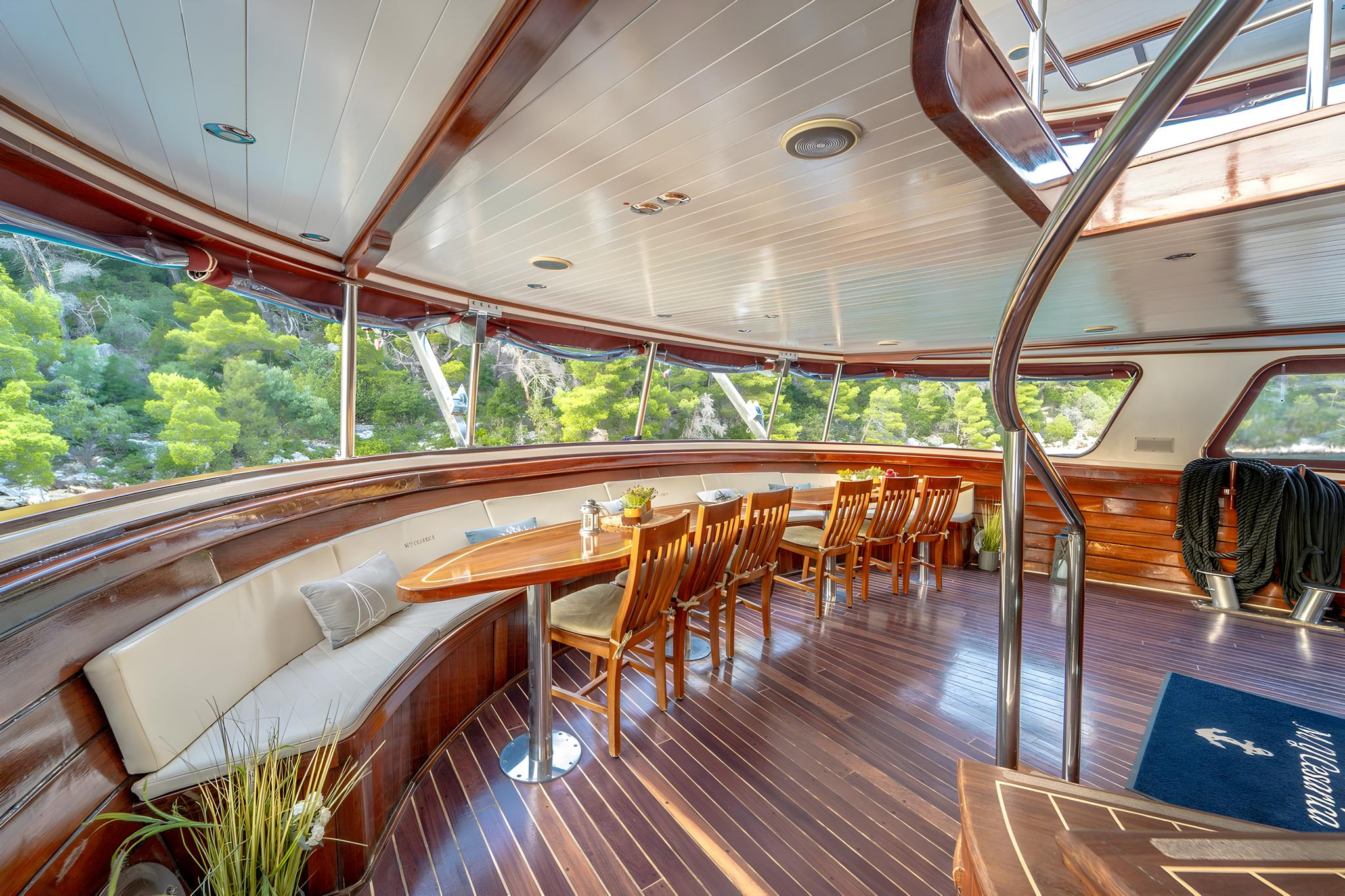luxury yacht interior salon with curved seating and panoramic coastal views