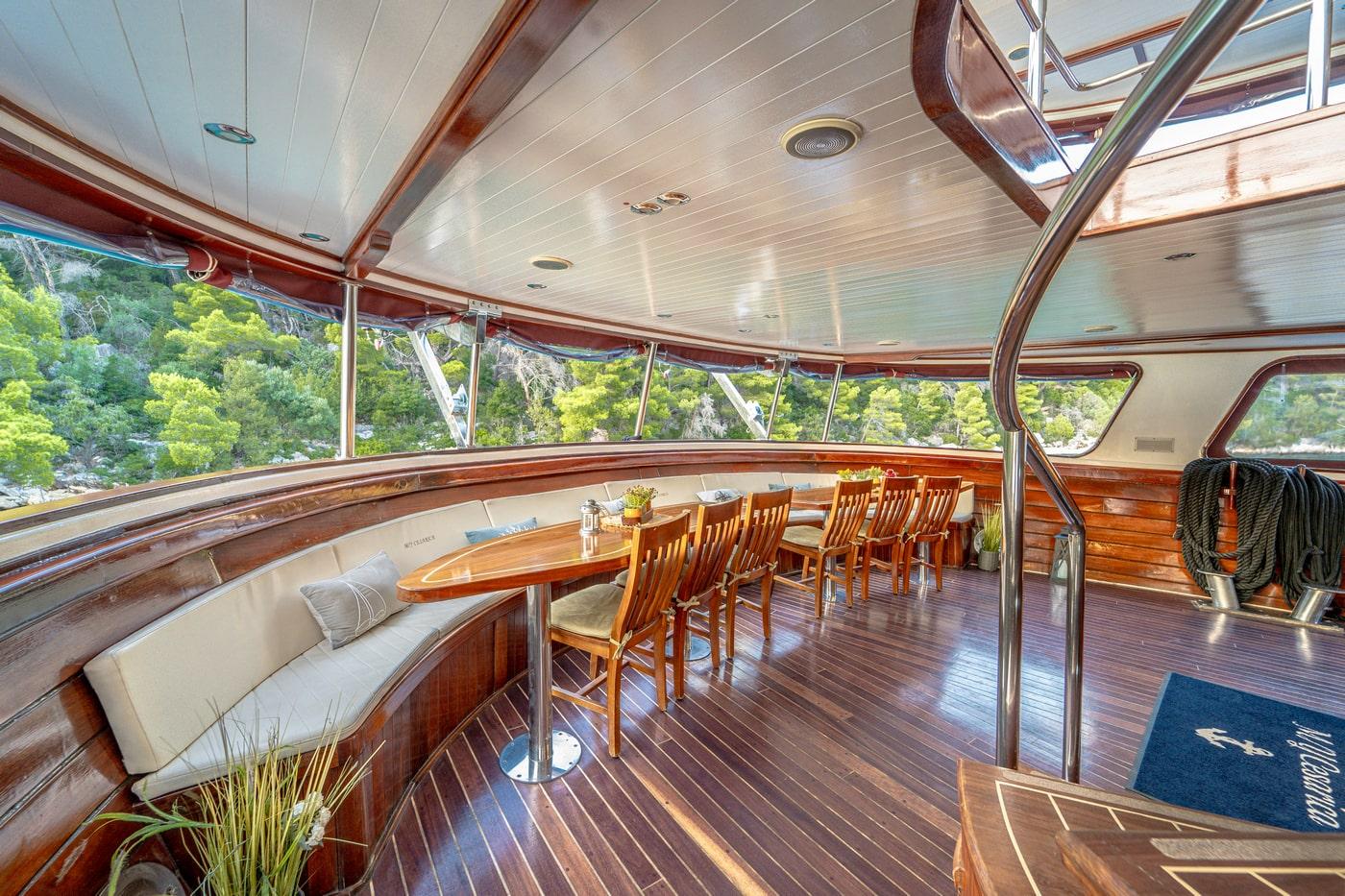 luxury yacht interior salon with curved seating and panoramic coastal views