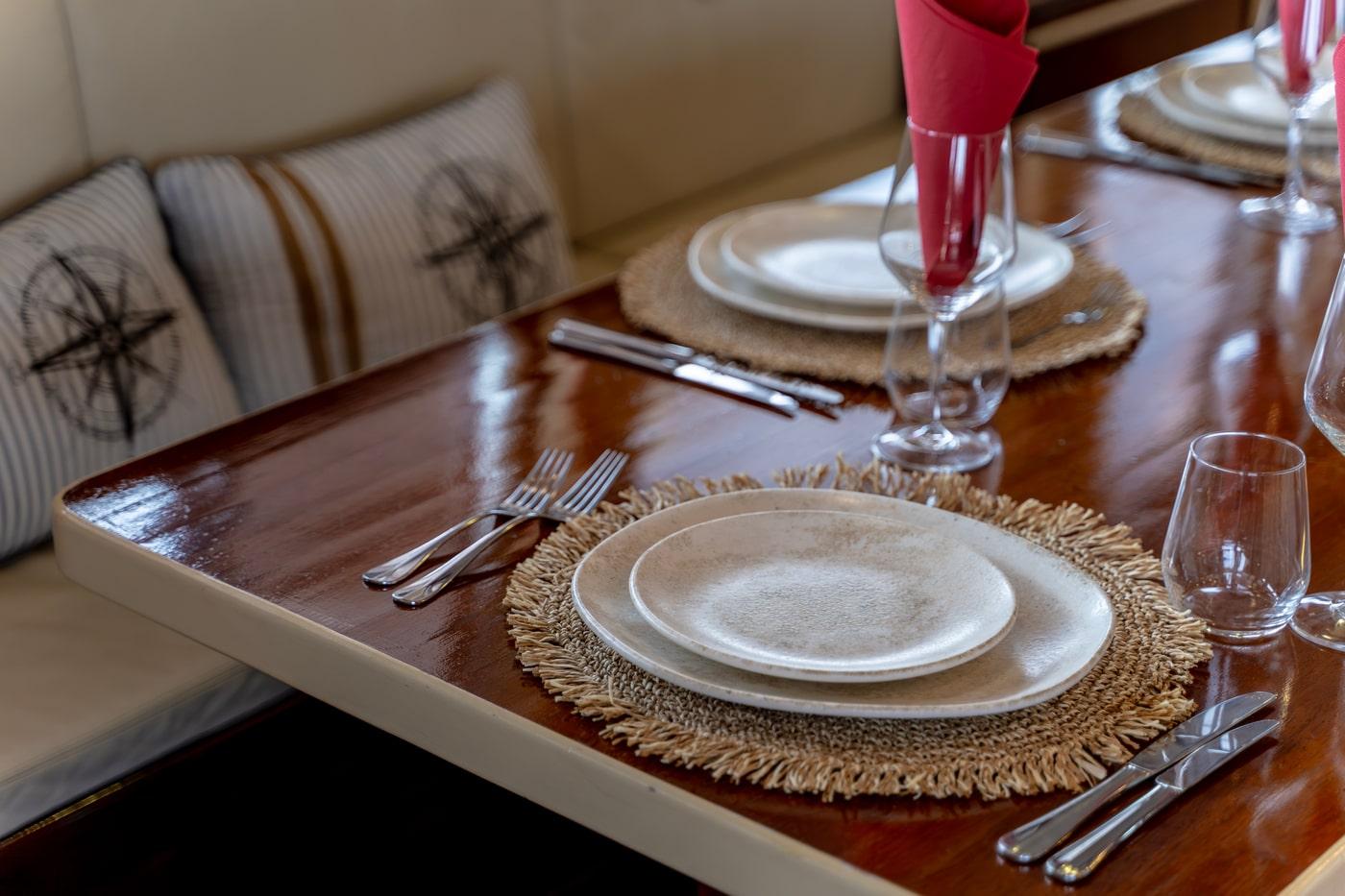 Luxury yacht dining table with formal place settings and banquette seating