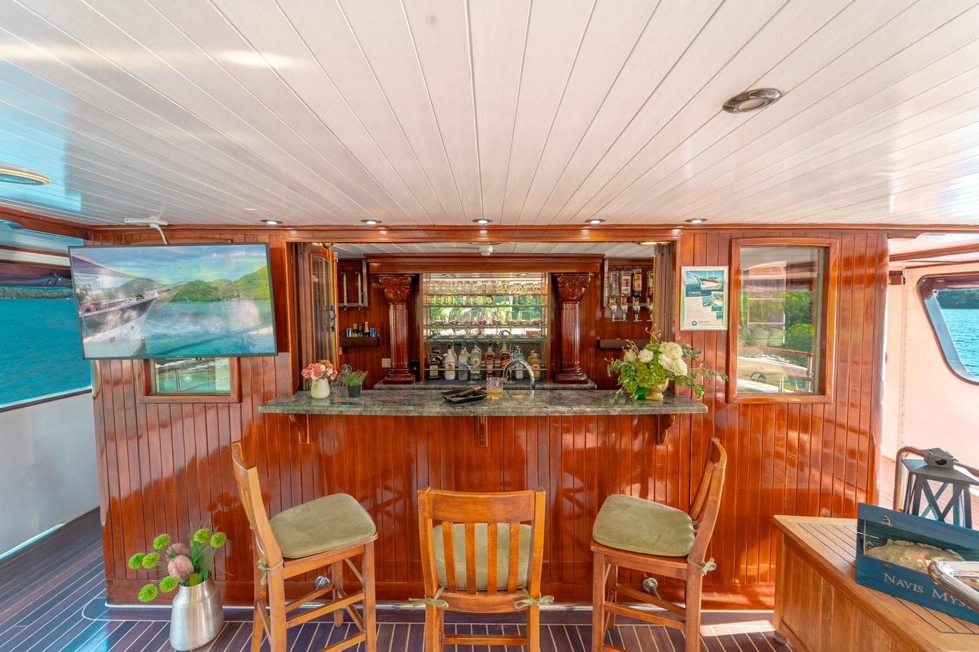luxury yacht salon bar with mahogany wood paneling and granite countertop