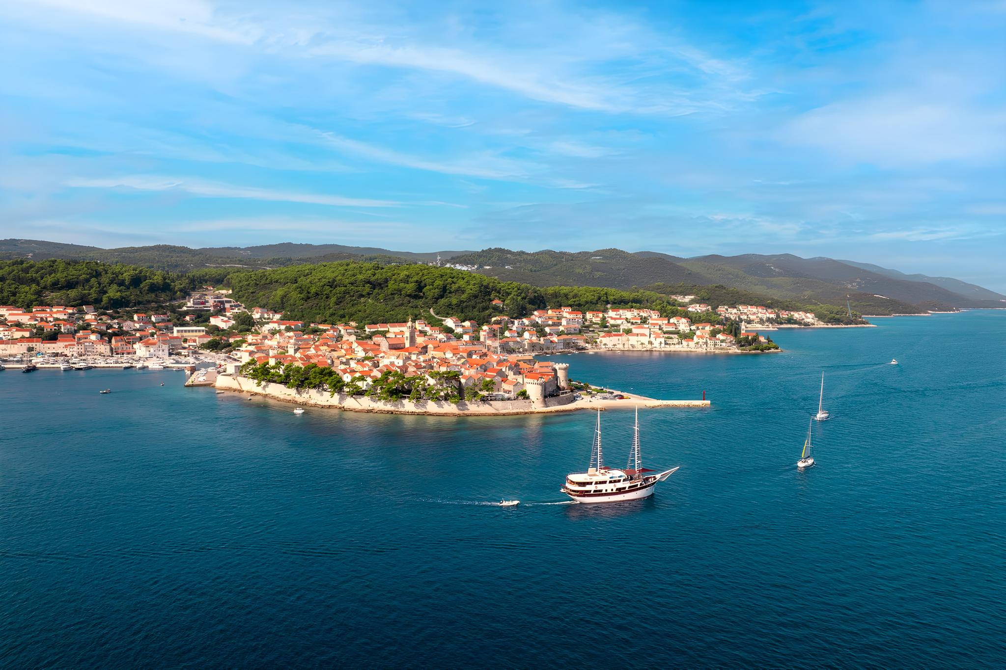 Traditional wooden gulet yacht anchored in blue waters near Mediterranean coastal town
