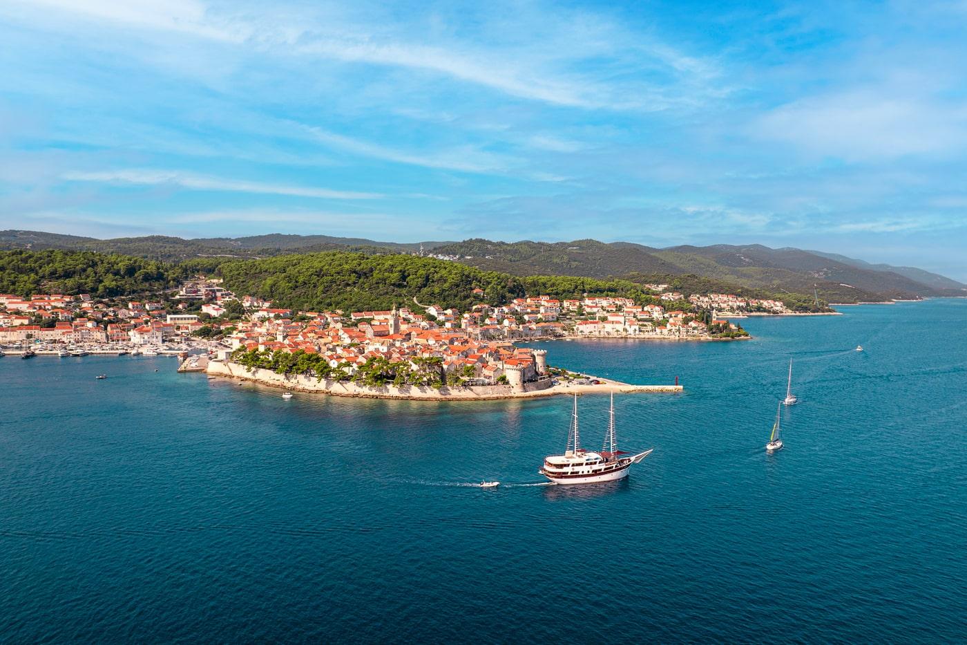 Traditional wooden gulet yacht anchored in blue waters near Mediterranean coastal town