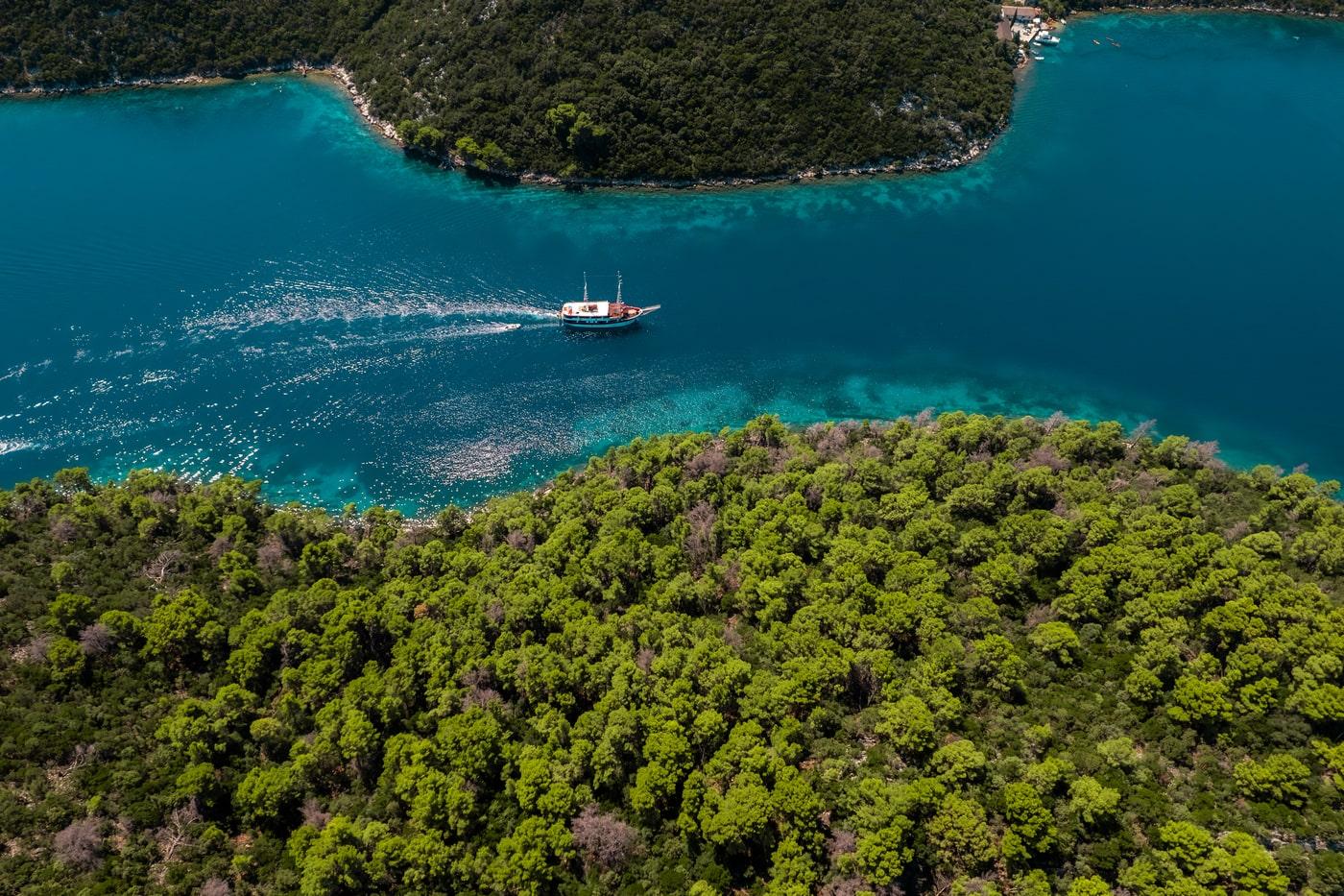Aerial view of traditional wooden gulet yacht sailing in pristine turquoise bay