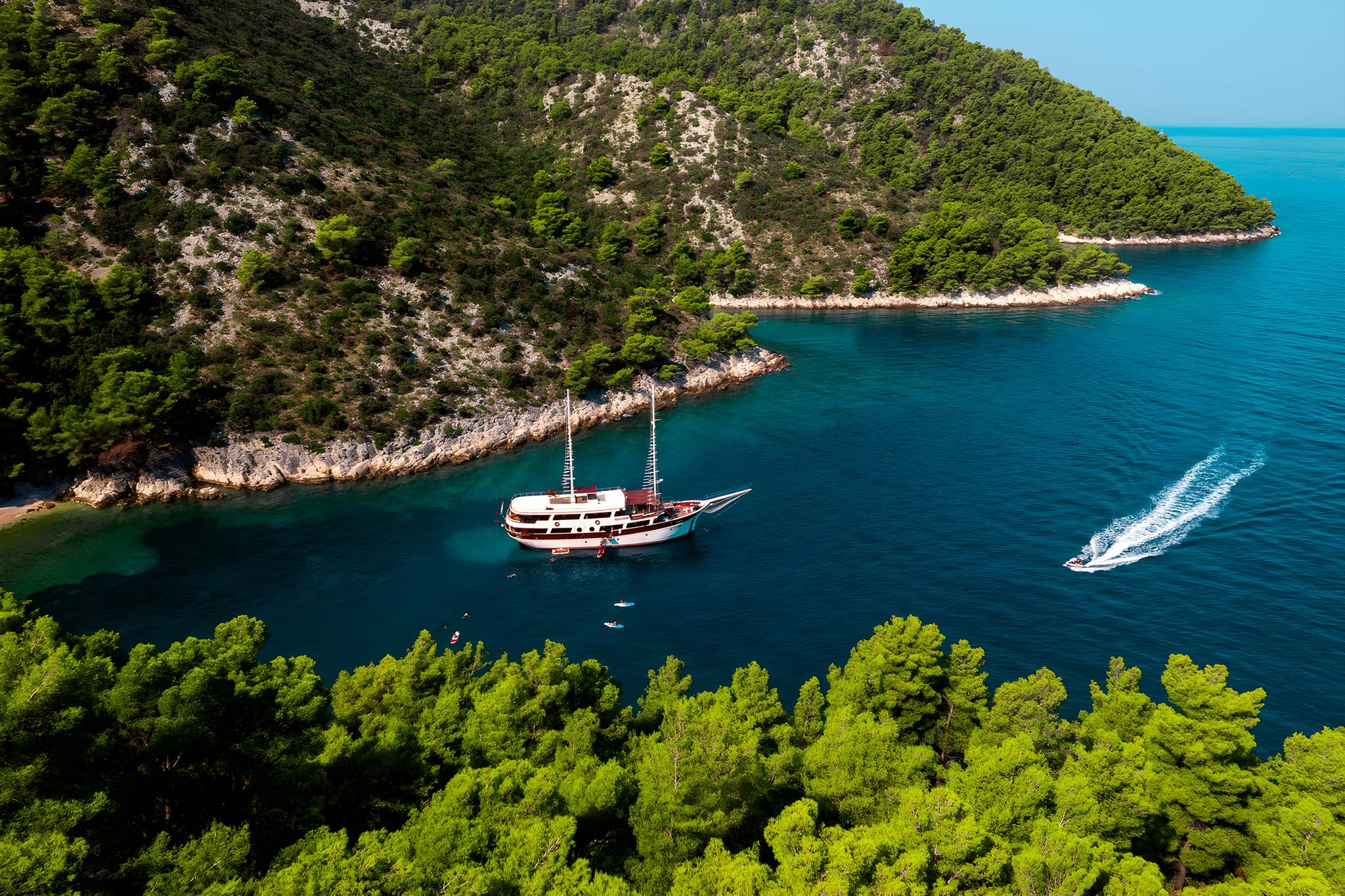 Aerial view of traditional gulet yacht anchored in turquoise Mediterranean bay