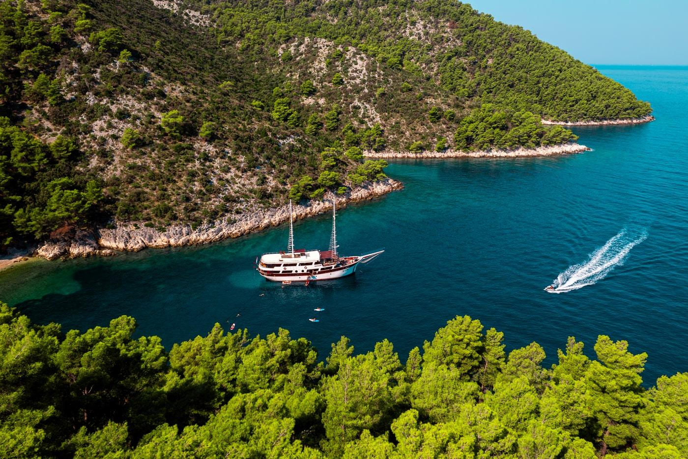 Aerial view of traditional gulet yacht anchored in turquoise Mediterranean bay