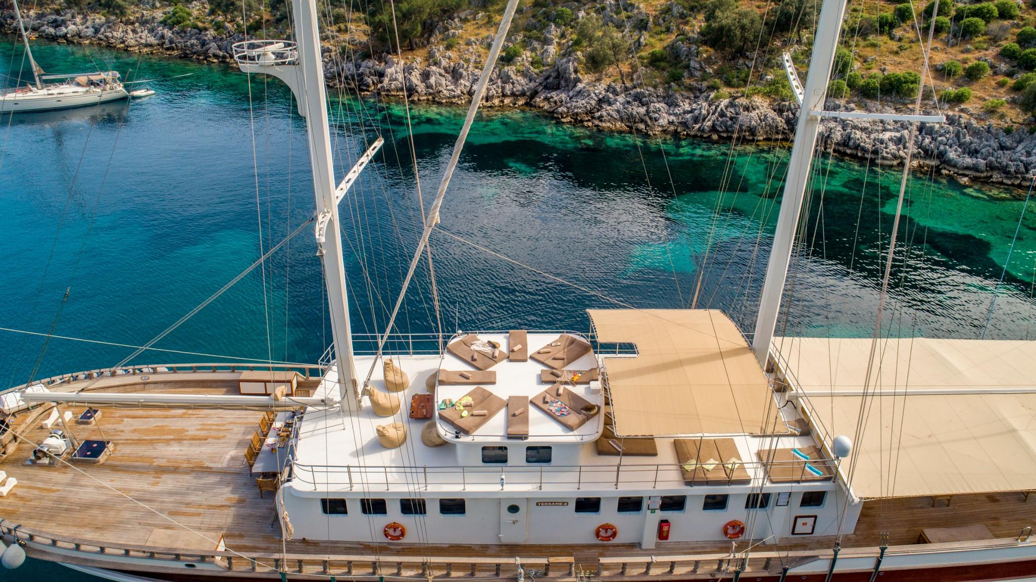 aerial view of traditional wooden gulet yacht anchored in crystal clear turquoise Mediterranean bay