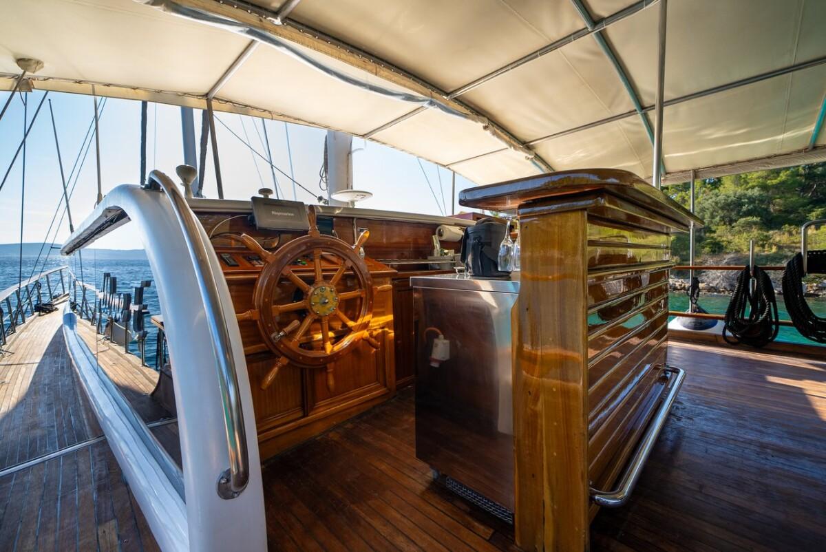 wooden gulet helm area with classic ship's wheel and navigation equipment