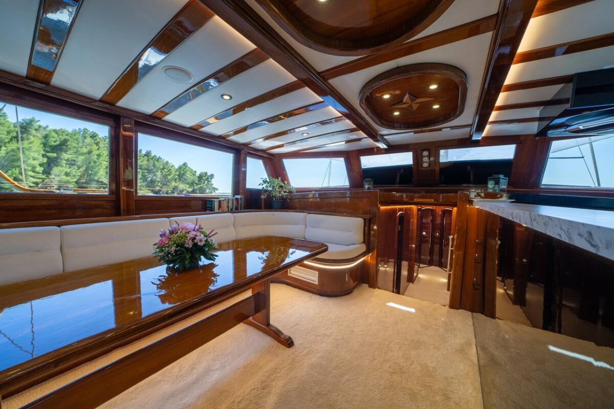 Elegant yacht salon with curved white leather seating and mahogany wood finishes