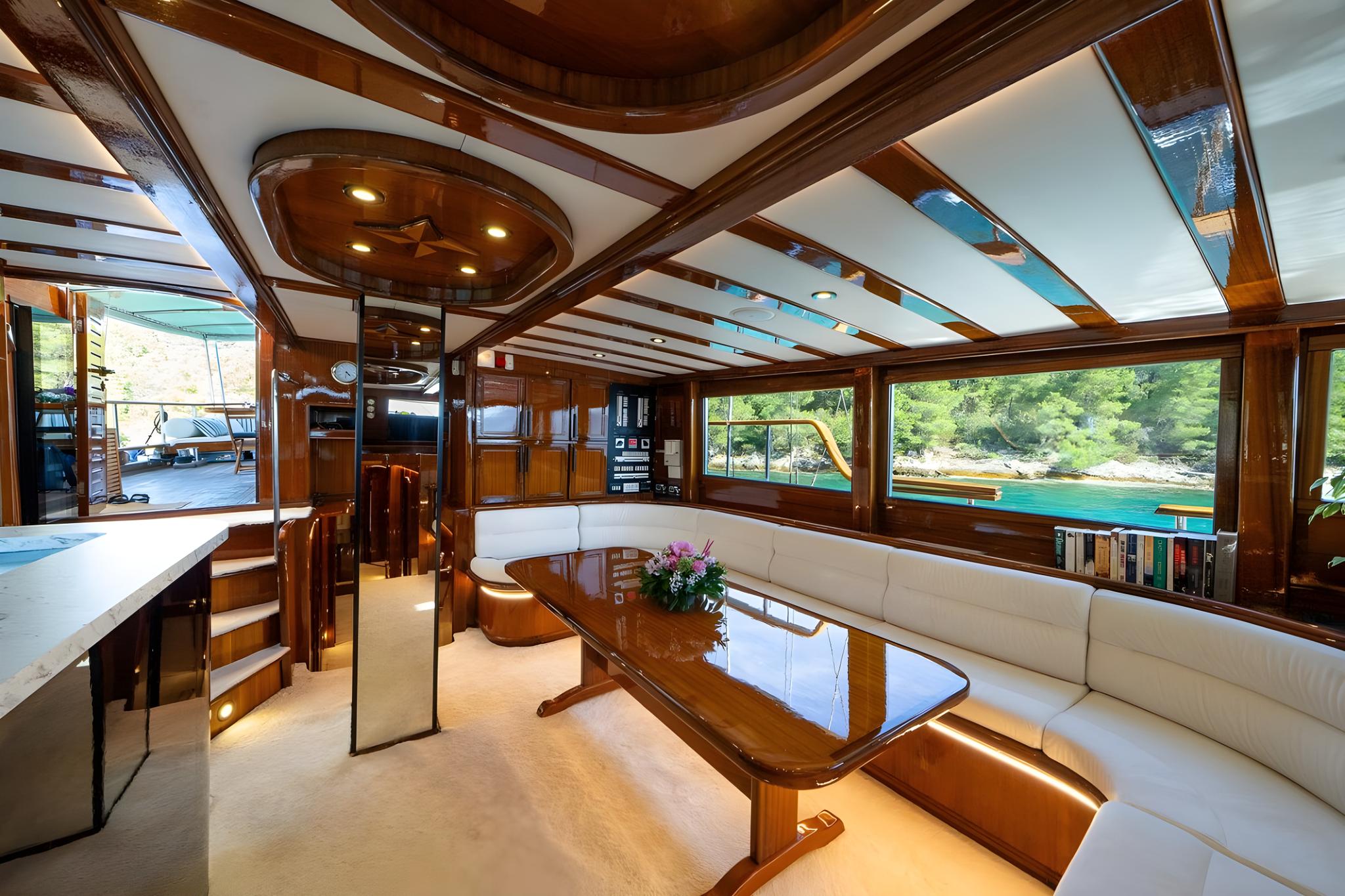 Elegant yacht salon interior with curved white leather seating and rich wood trim