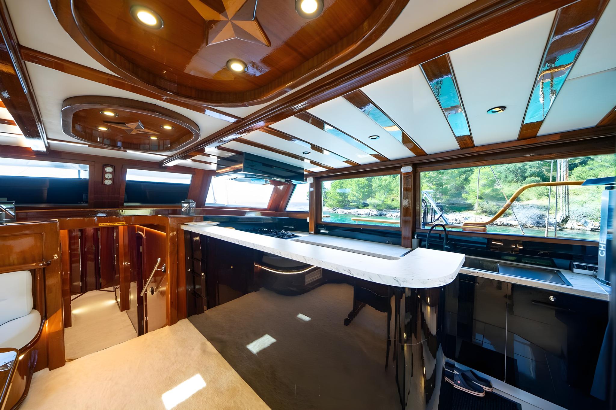 Elegant yacht salon interior featuring marble bar counter and carved wooden ceiling