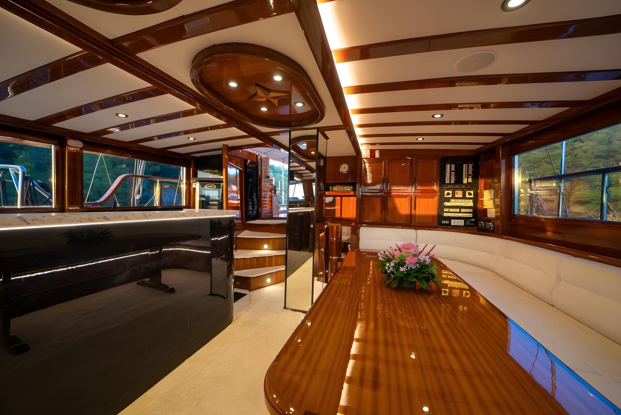 Elegant yacht salon interior with mahogany wood paneling and curved dining table