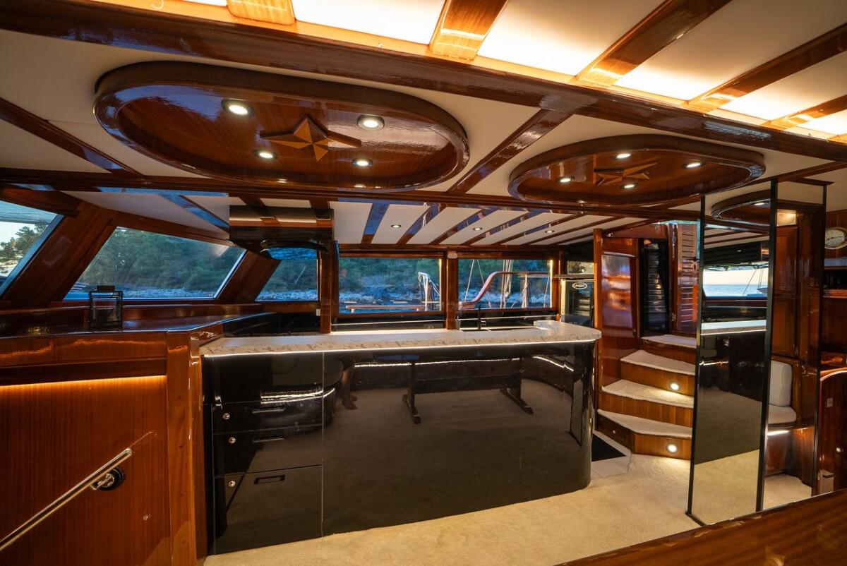 Luxury yacht galley featuring central island dark countertops wood paneling oval ceiling lights