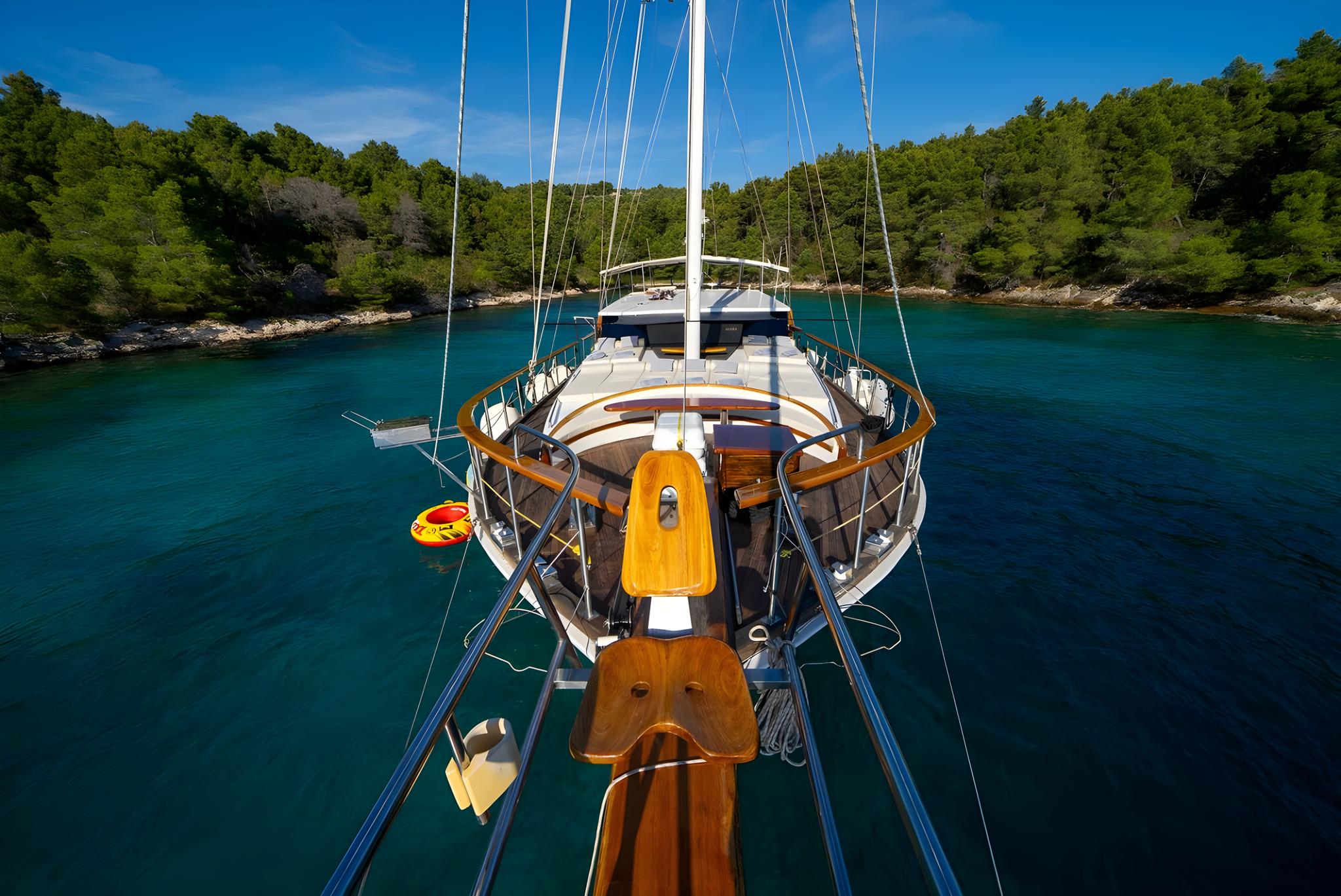 Aerial view of traditional wooden gulet yacht anchored in pristine turquoise Mediterranean cove