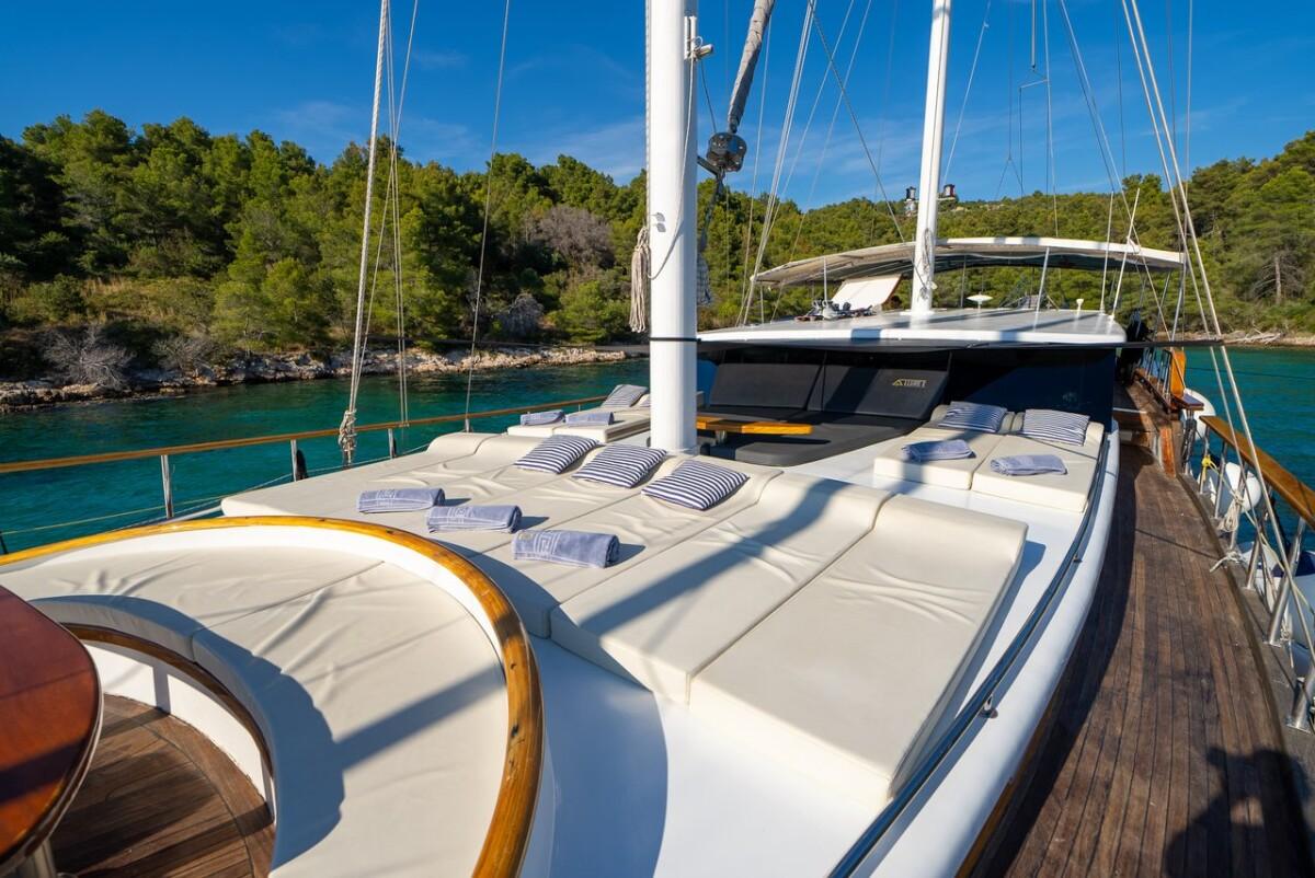 luxury gulet foredeck sunbathing cushions overlooking turquoise Mediterranean bay