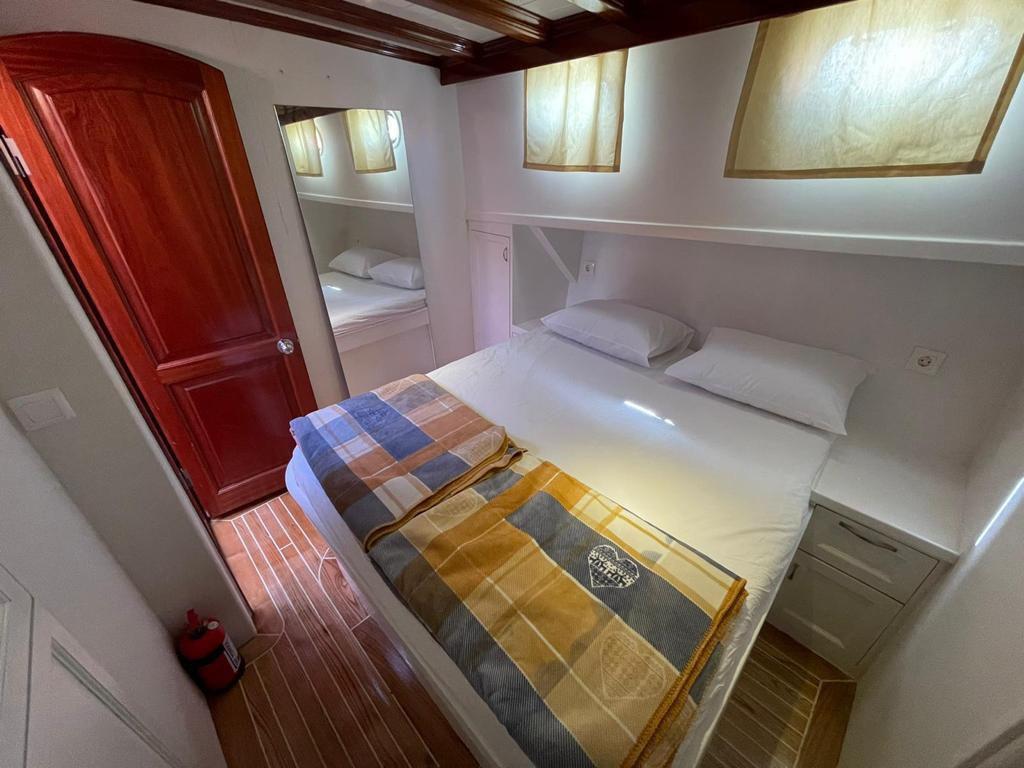 yacht guest cabin featuring built-in double bed with white linens and integrated storage cabinets