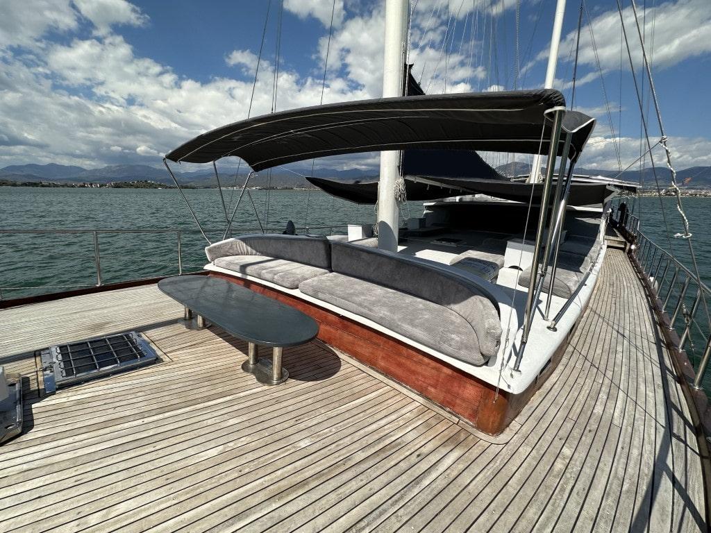 yacht forward deck with built-in daybed, cushions, shade canopy and teak decking