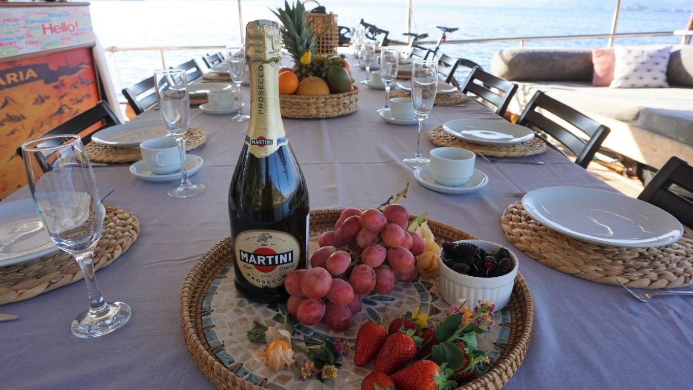 yacht dining table with Martini Prosecco, fresh grapes, strawberries and fruit baskets