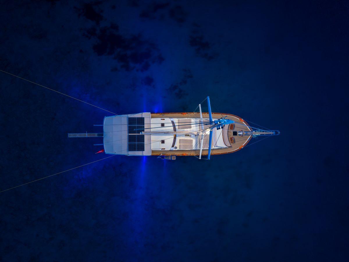 aerial drone shot of traditional gulet yacht anchored in deep blue Mediterranean waters