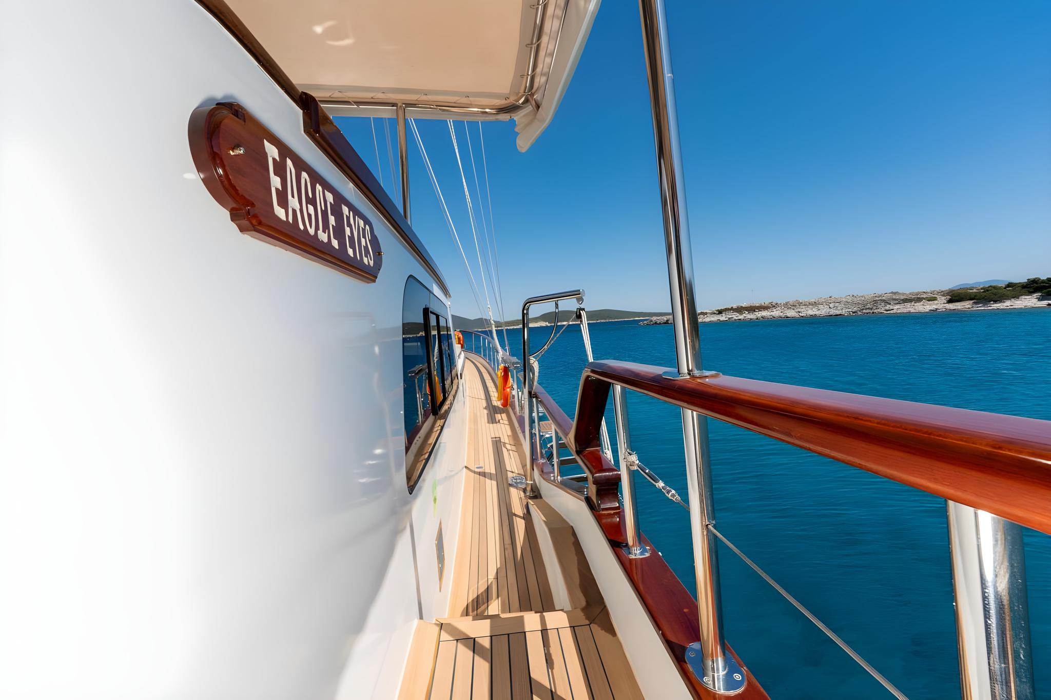 Eagle Eyes yacht side deck with teak decking, mahogany handrails and vessel name plaque