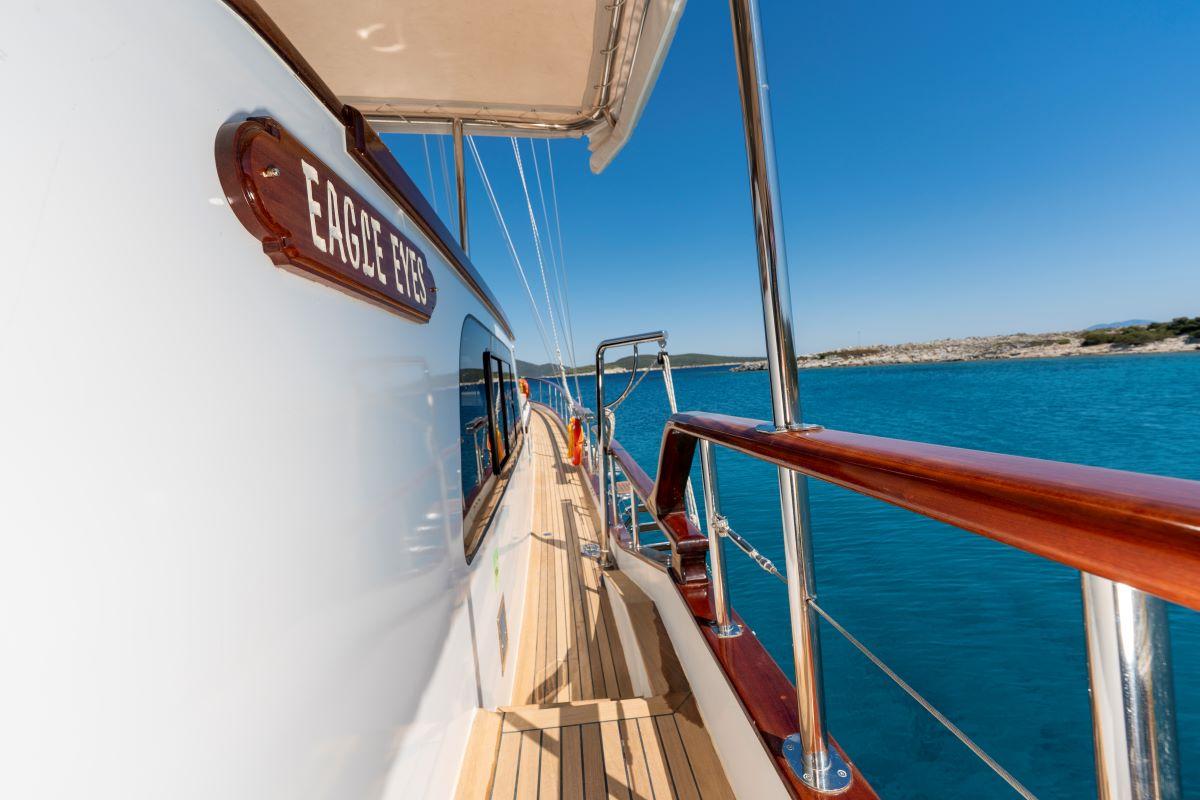 Eagle Eyes yacht side deck with teak decking, mahogany handrails and vessel name plaque