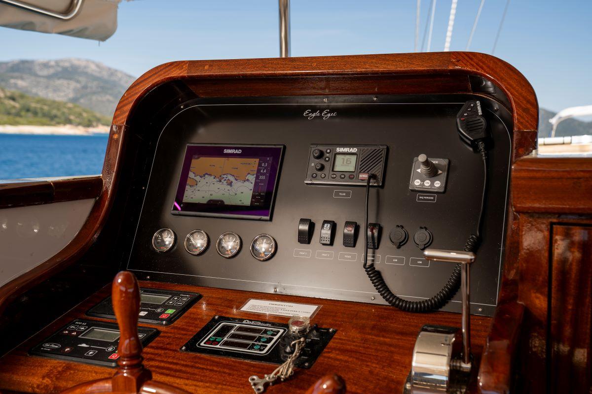 yacht helm station featuring SIMRAD chartplotter, engine controls, gauges and VHF radio