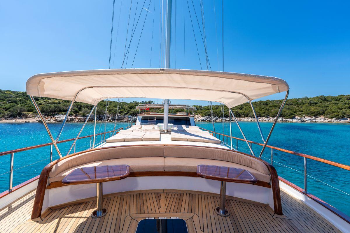 curved stern seating with purple cushions and bimini canopy overlooking turquoise bay