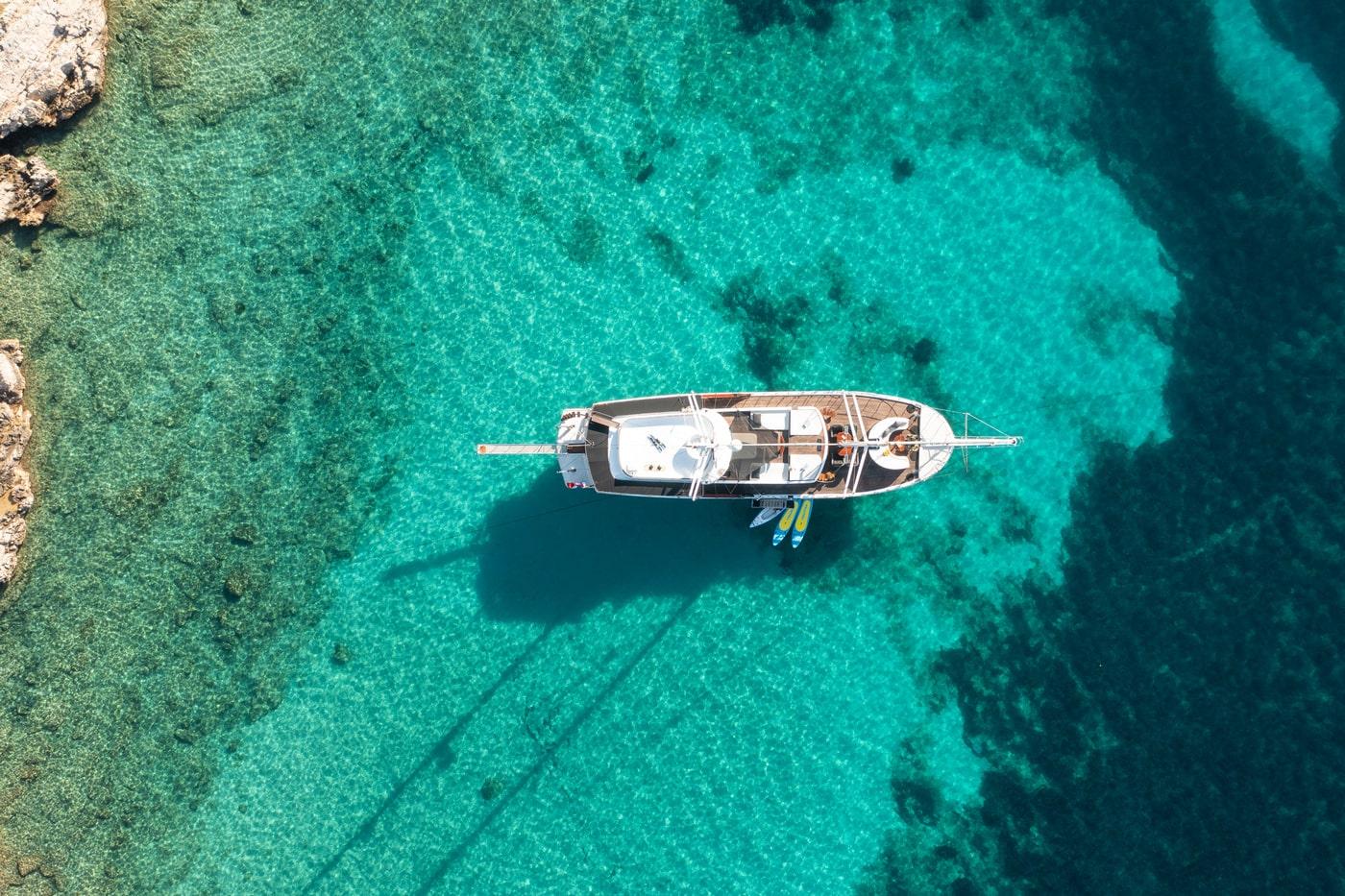 aerial view of luxury yacht anchored in crystal clear turquoise bay