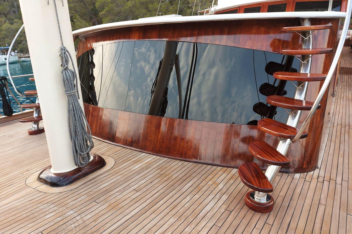 yacht curved superstructure with tinted windows and exterior bar stools on teak deck