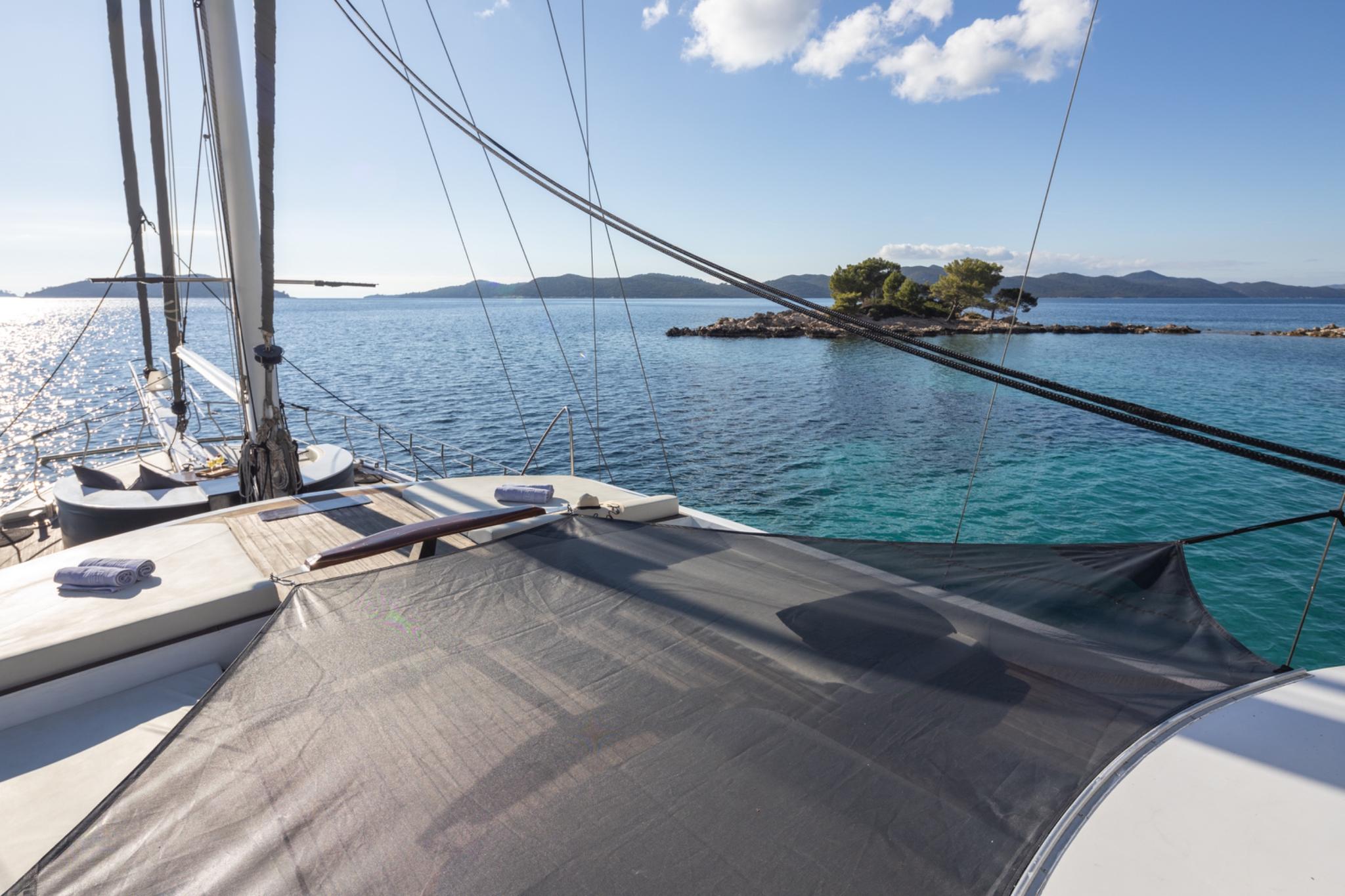 gulet bow deck with trampolines, mast rigging, and turquoise Mediterranean waters