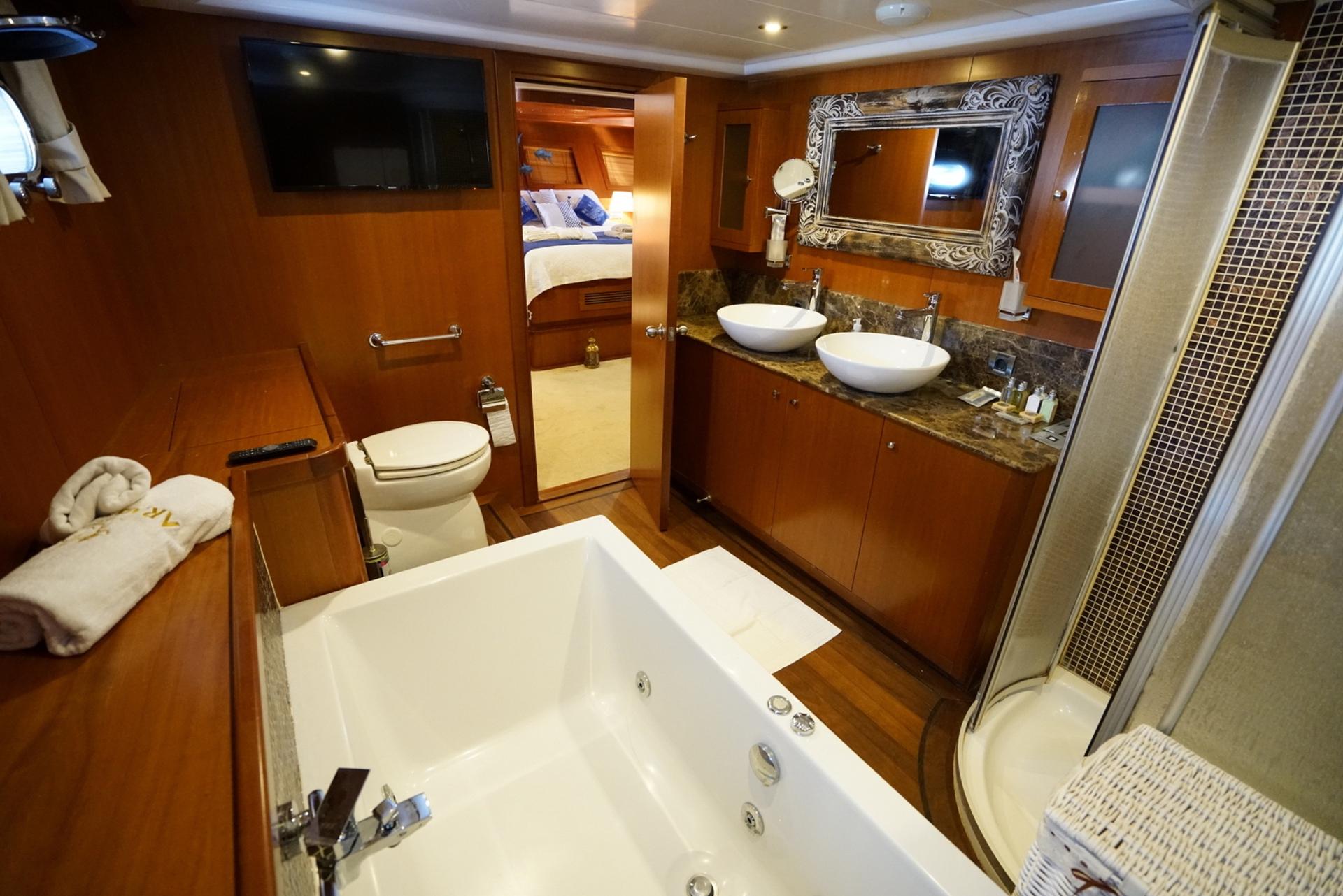 luxury master cabin en-suite bathroom with jacuzzi tub, double vanity, ornate mirror