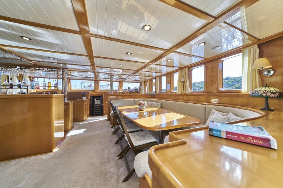 luxury yacht interior salon with dining table banquette seating galley