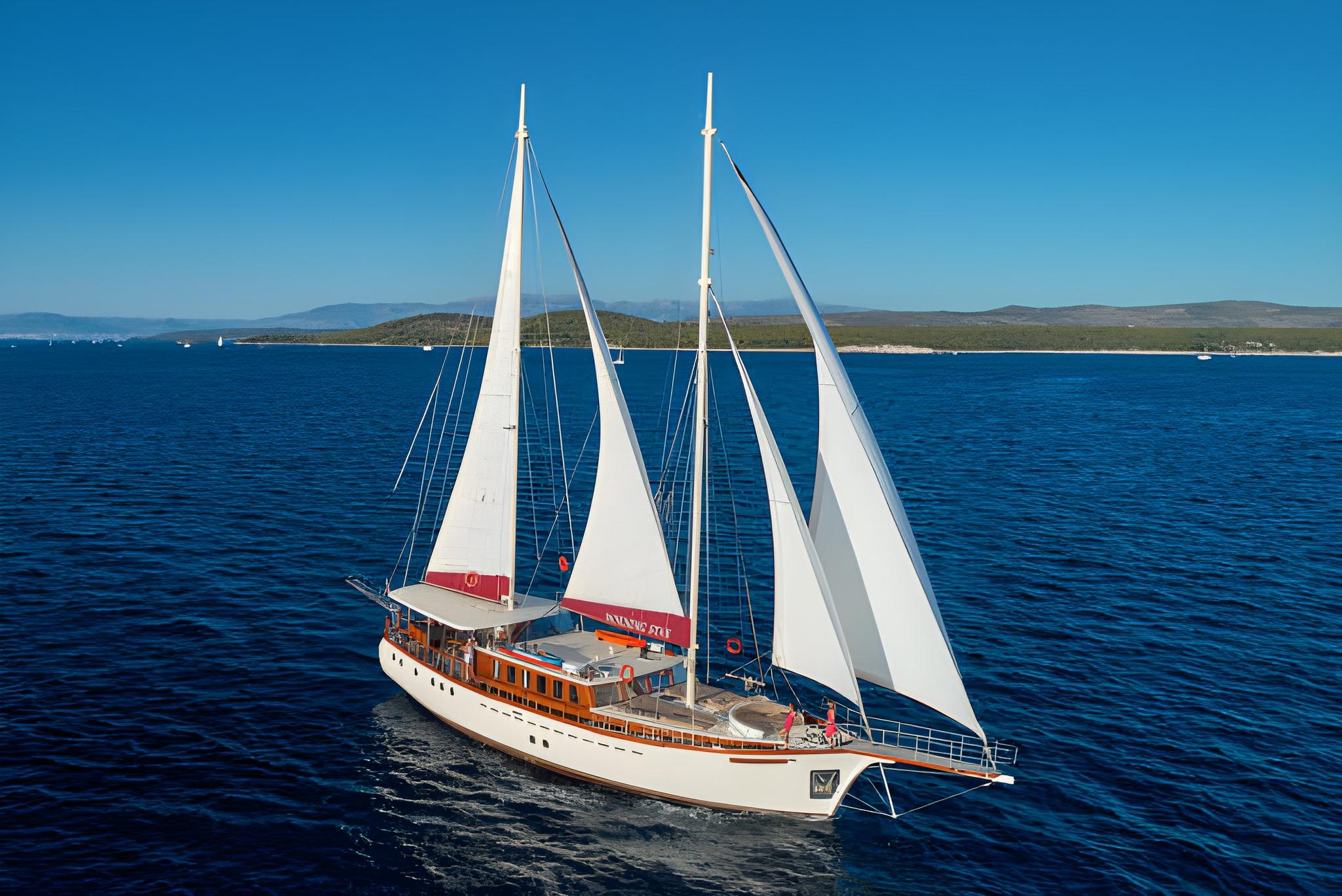 Traditional wooden sailing gulet with white sails cruising blue Mediterranean waters