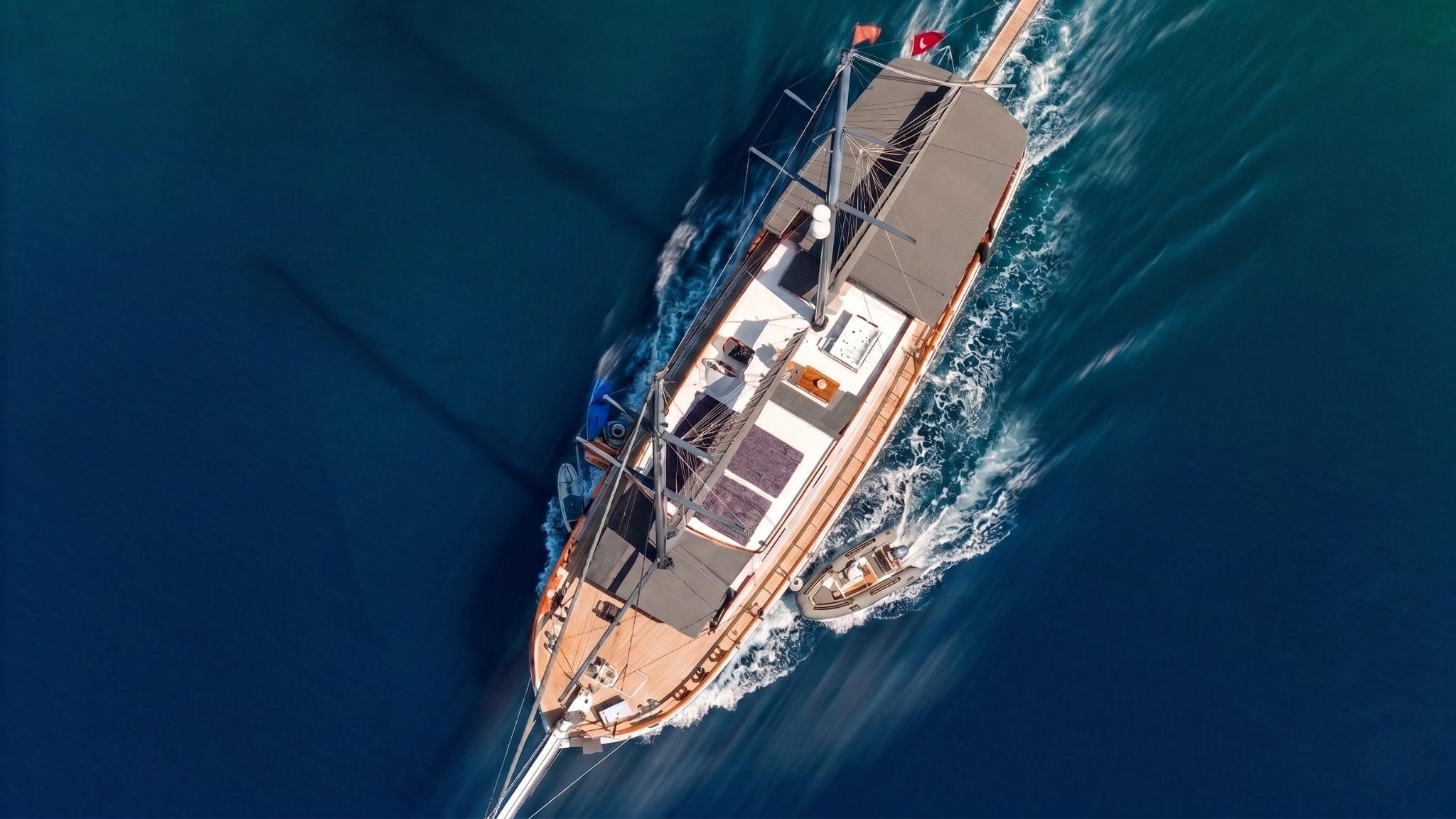 aerial view of traditional wooden gulet yacht sailing through deep blue Mediterranean waters